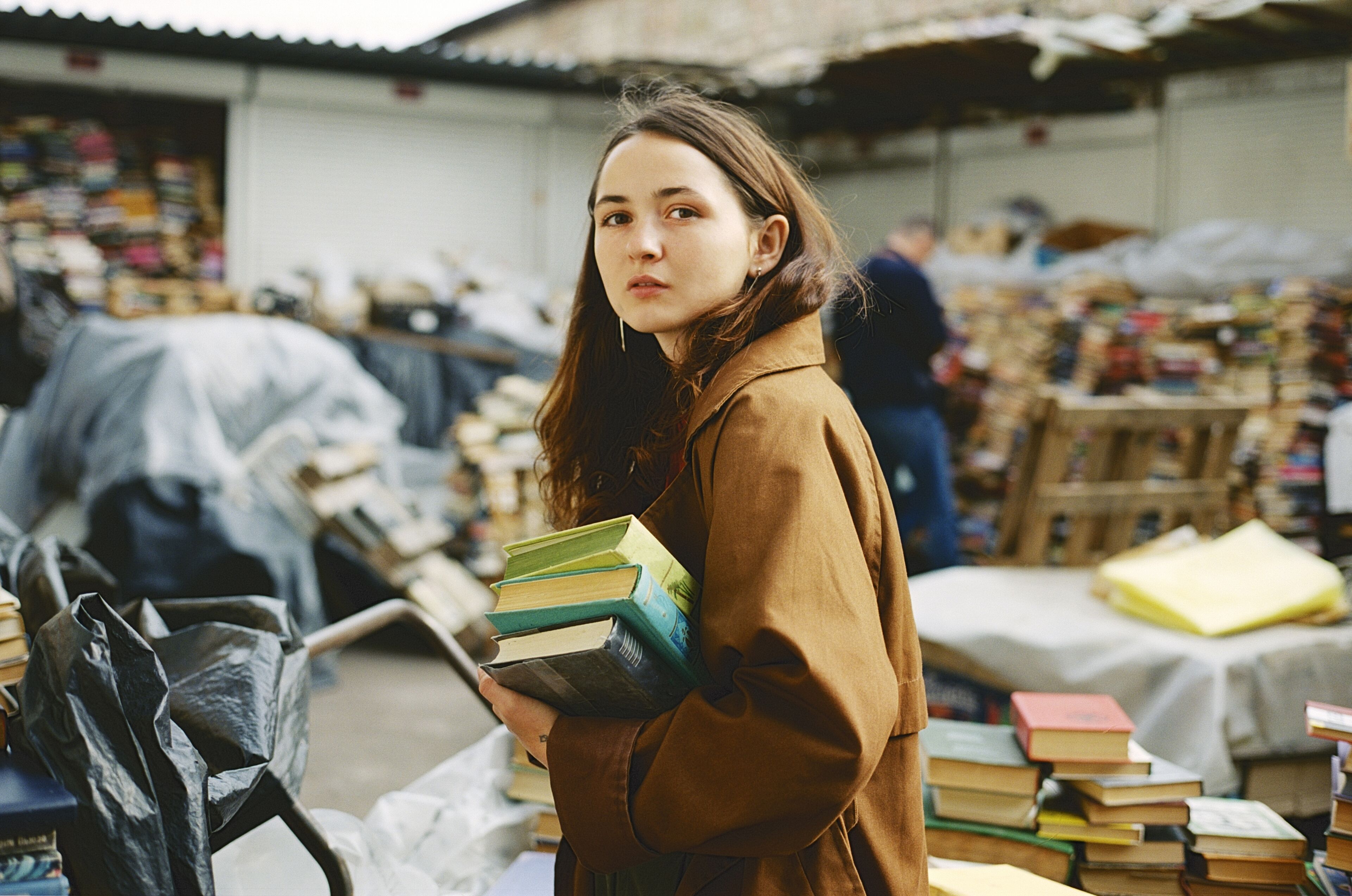 Young Caucasian woman buying books on vintage book market