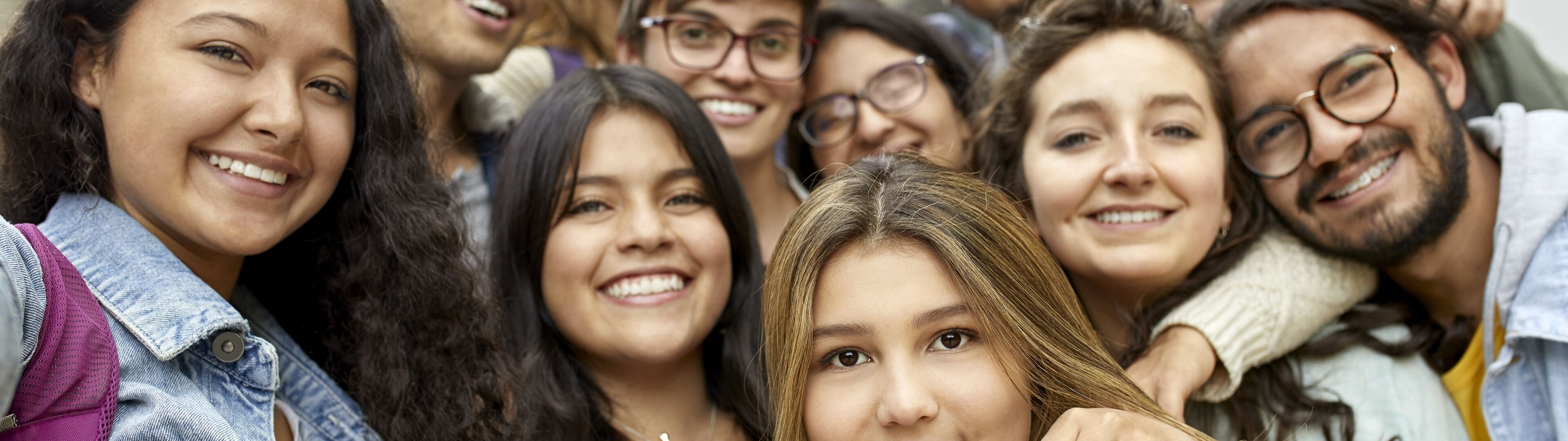Un alegre grupo de estudiantes diversos posando juntos para una selfie cercana.