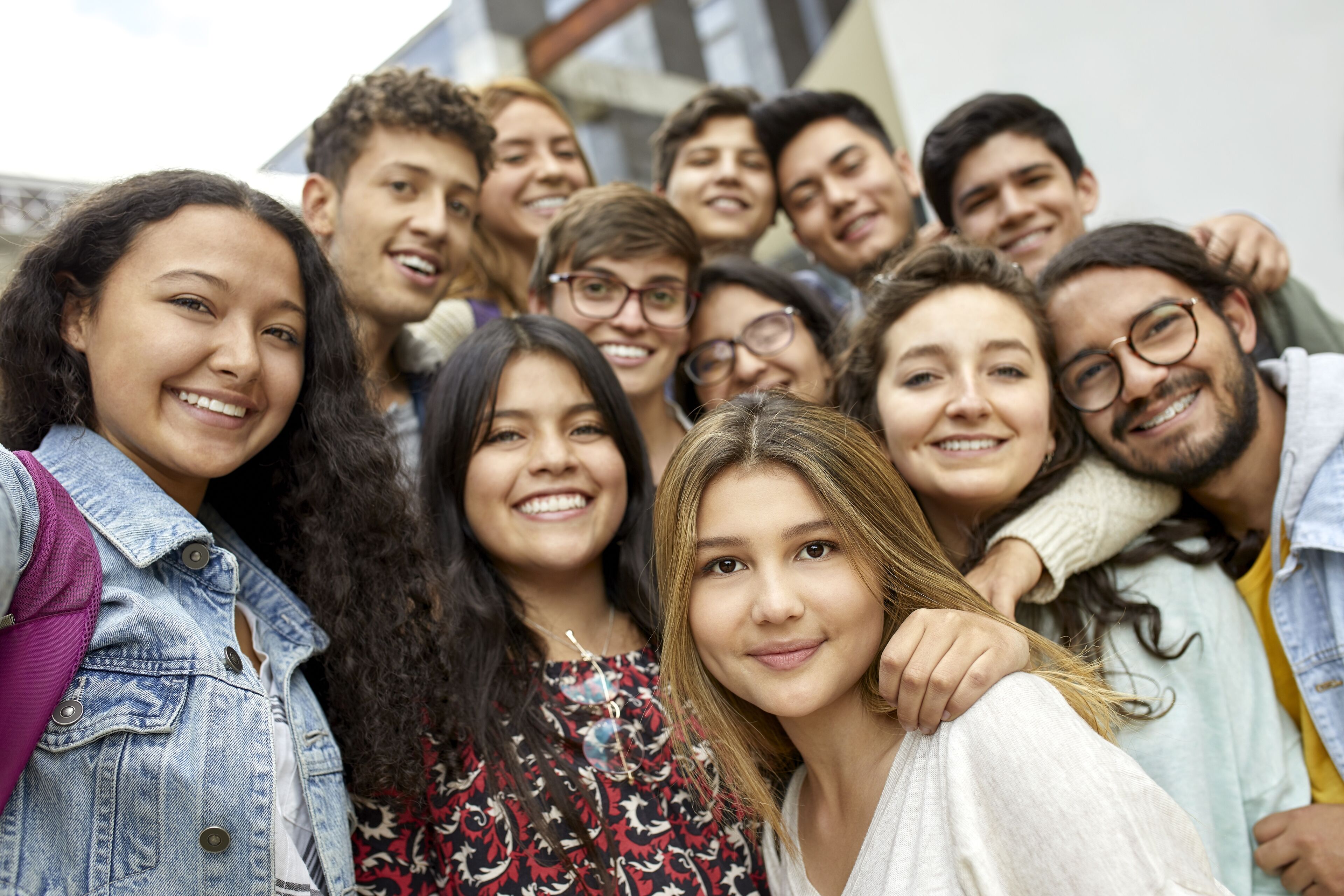A cheerful group of diverse students posing together for a close-up selfie.