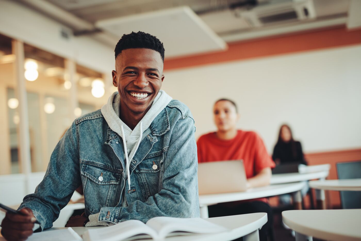 African student sitting in classroom. Male student smiling during the lecture in high school classroom.