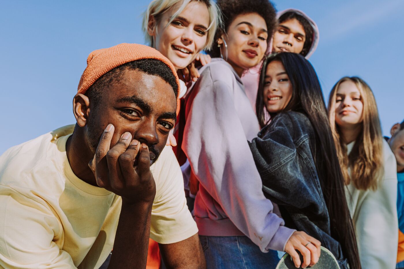 Multicultural group of young friends bonding outdoors and having fun - Stylish cool teens gathering at urban skate park