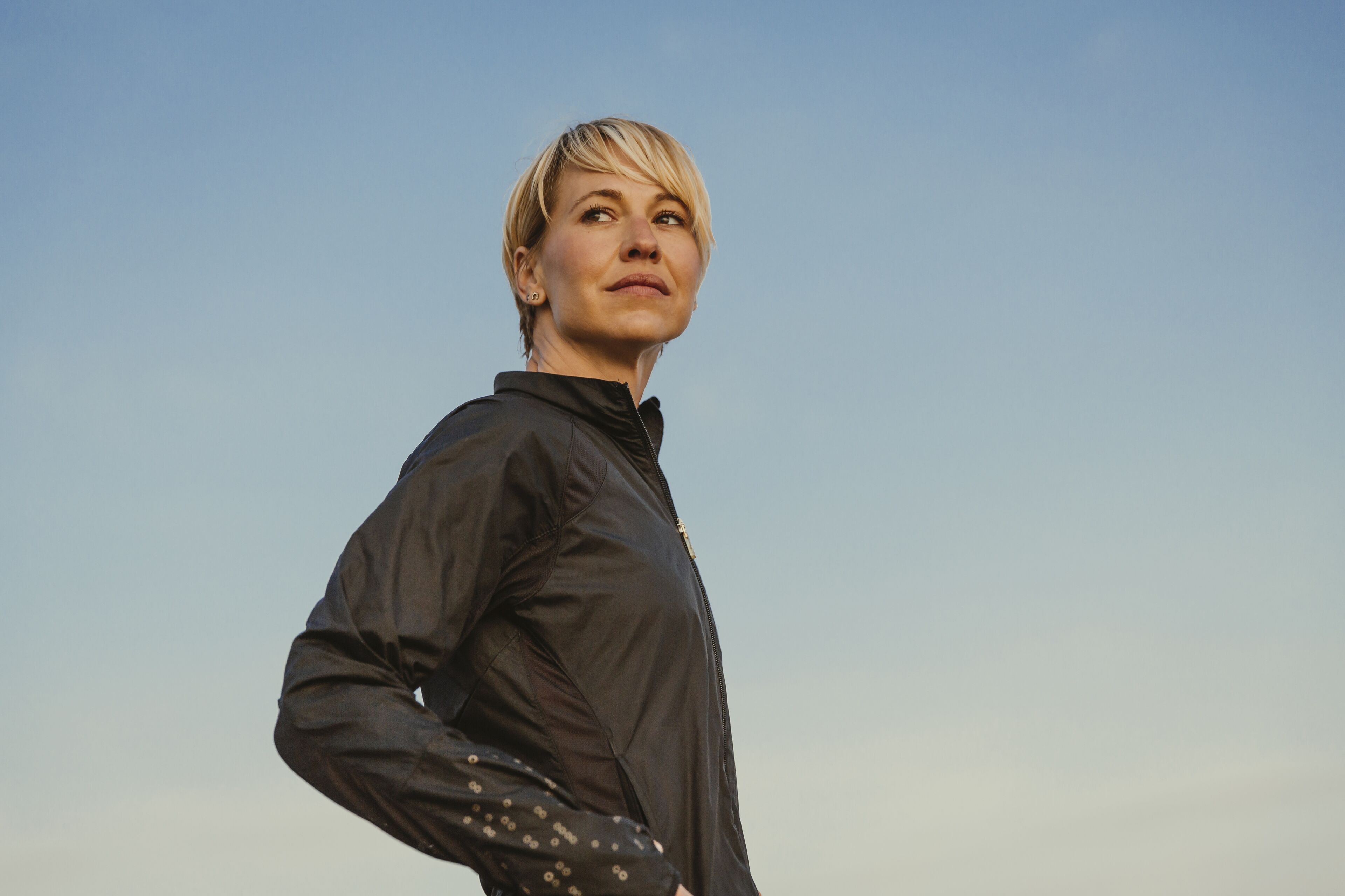 Portrait of beautiful woman standing against blue sky