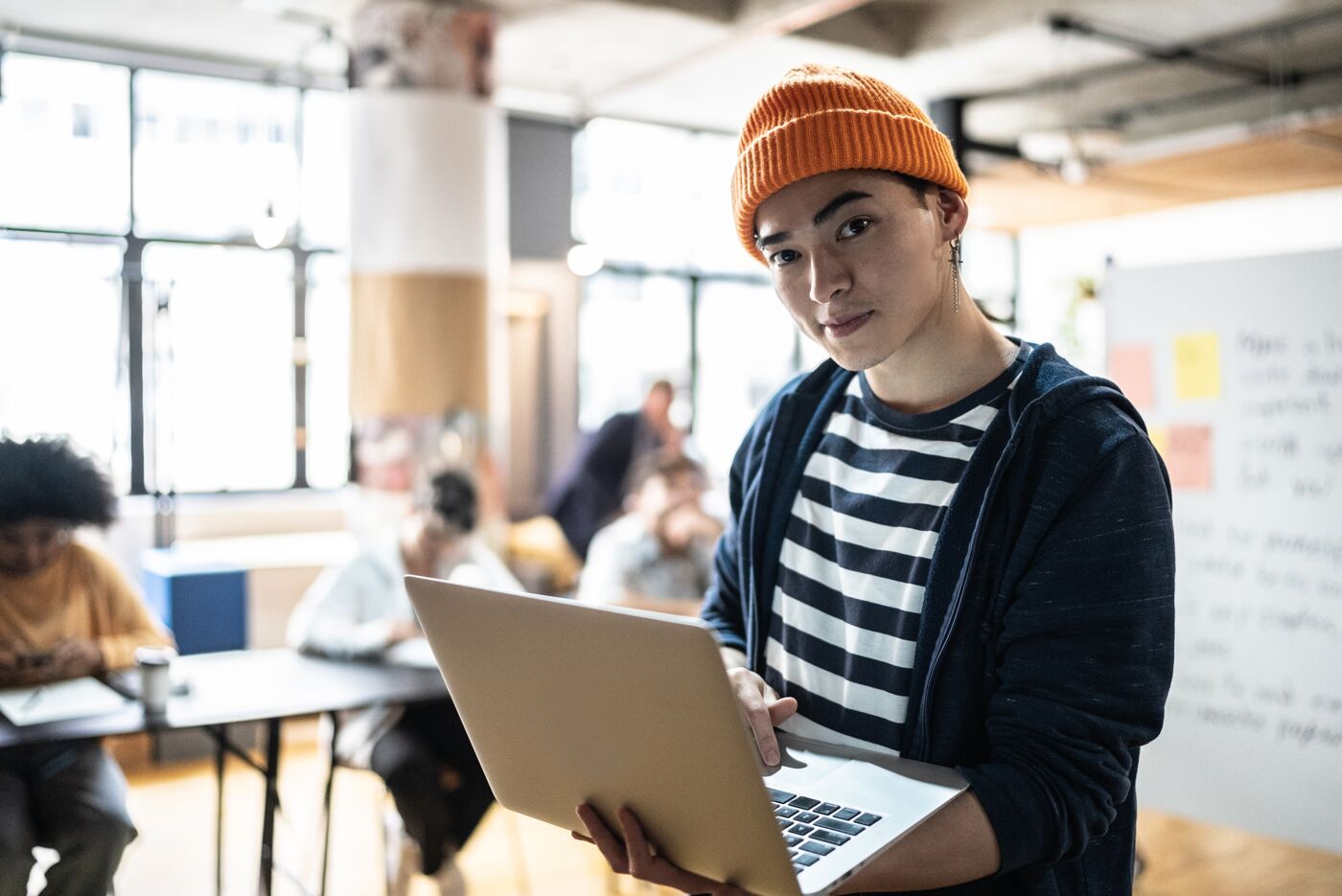 Portrait of a young man holding the laptop in the classroom or small business