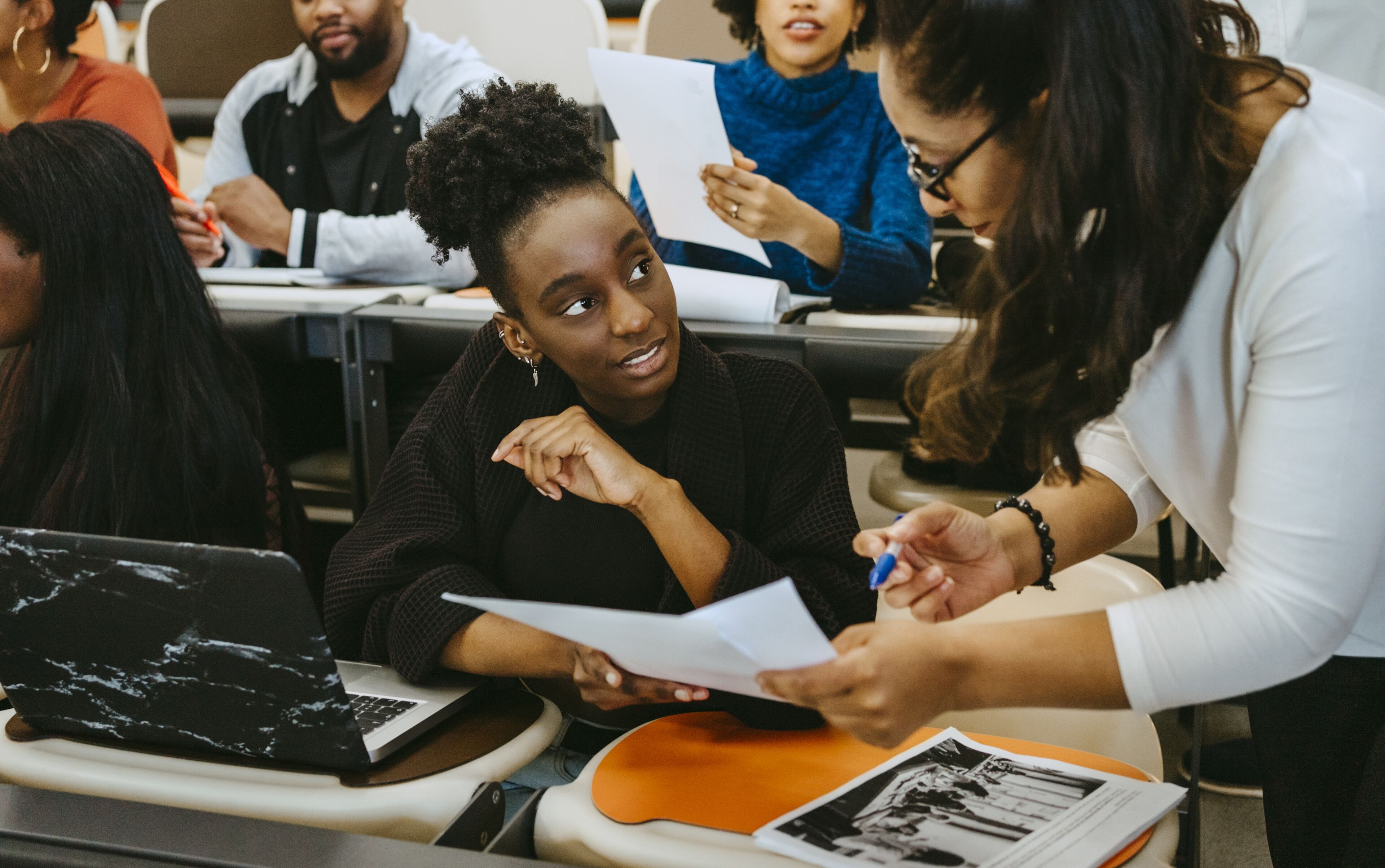 Female student and teacher discussing over test result in class