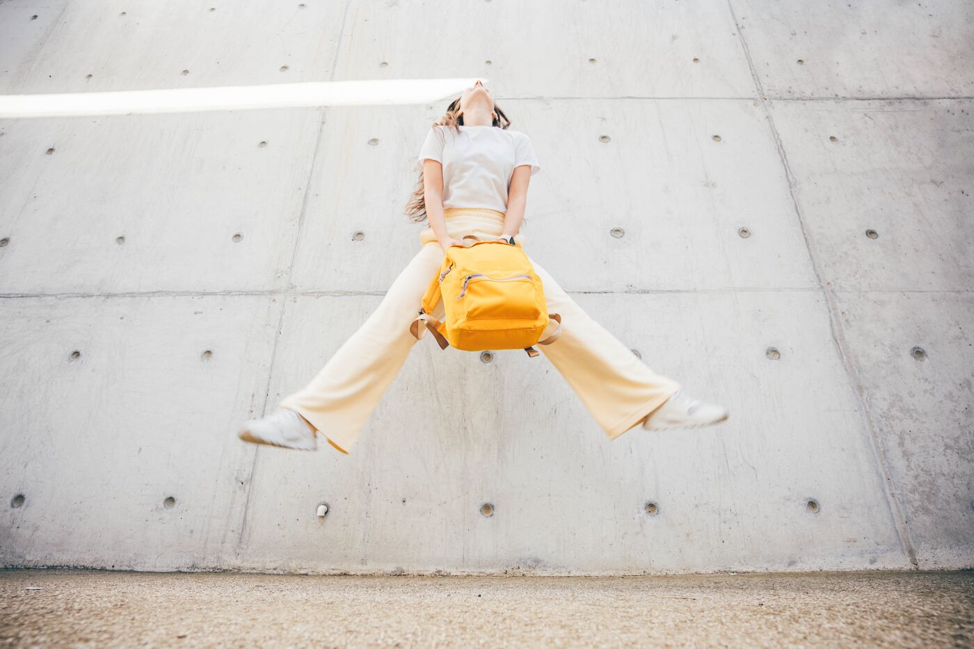 Happy Young Woman Jumping Against Wall.