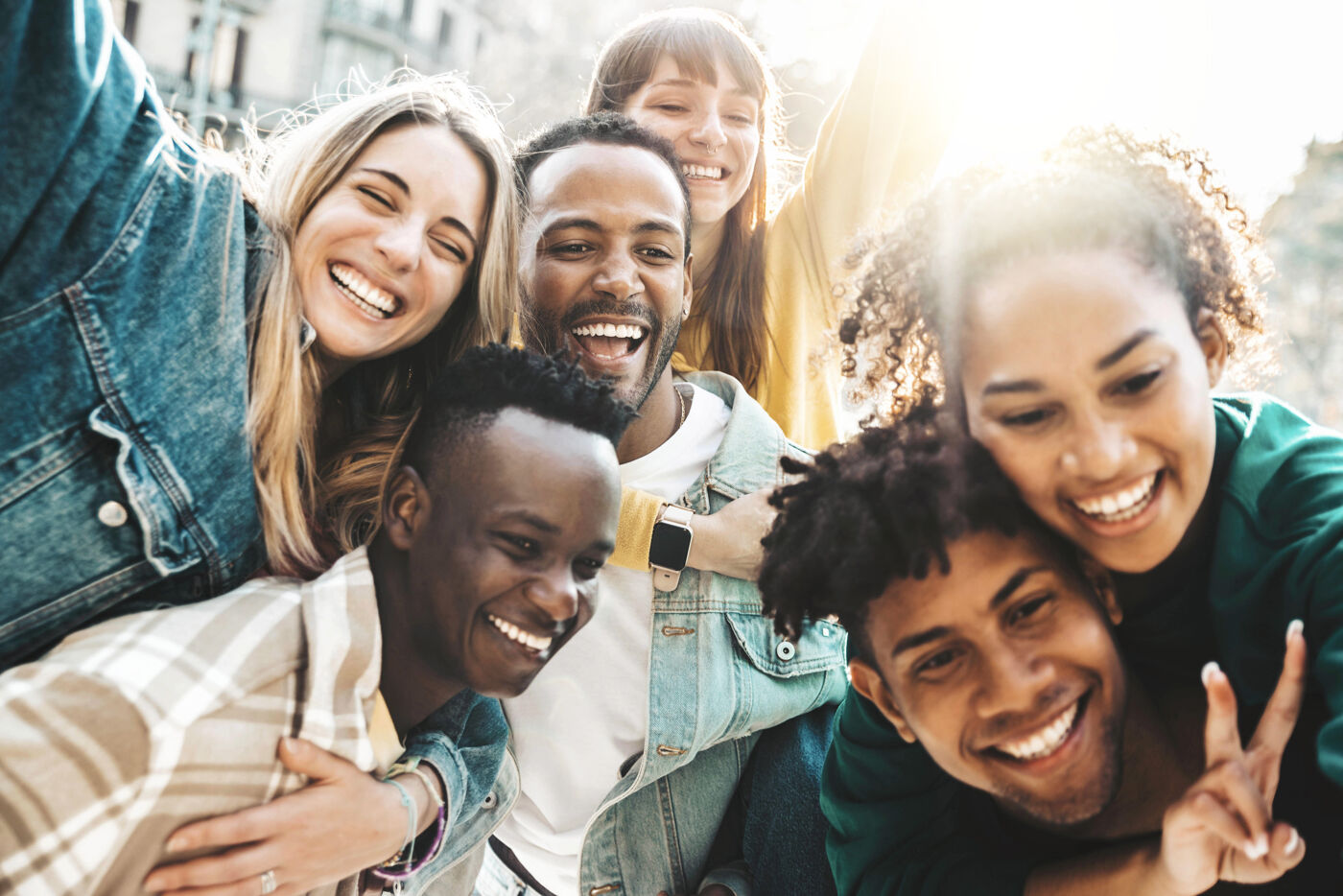 Happy multiracial friends having fun hanging out on city street - Group of young people laughing out loud together outside - Friendship concept with guys and girls enjoying weekend