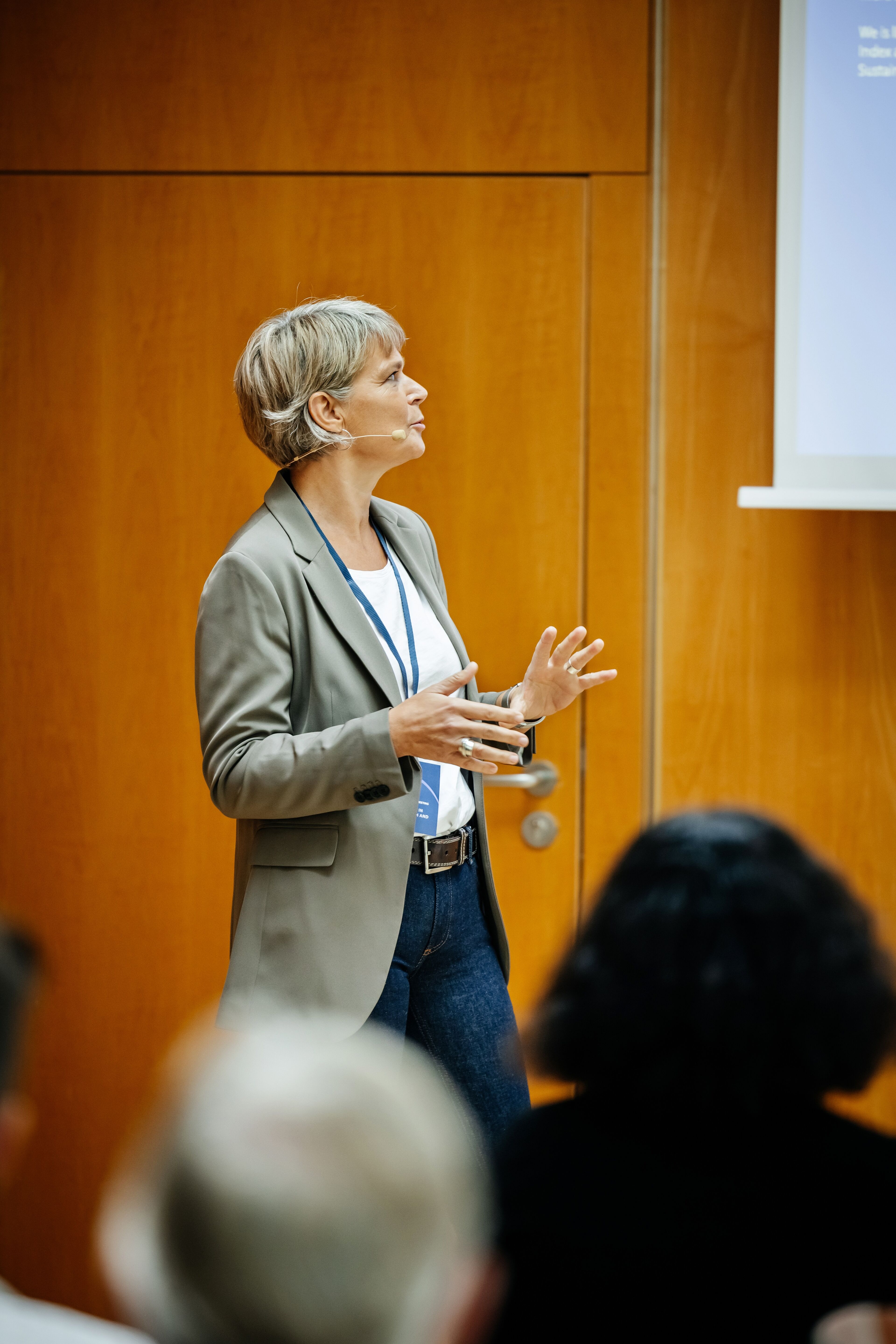 A businesswoman giving a presentation to a group of attendees at a business convention.