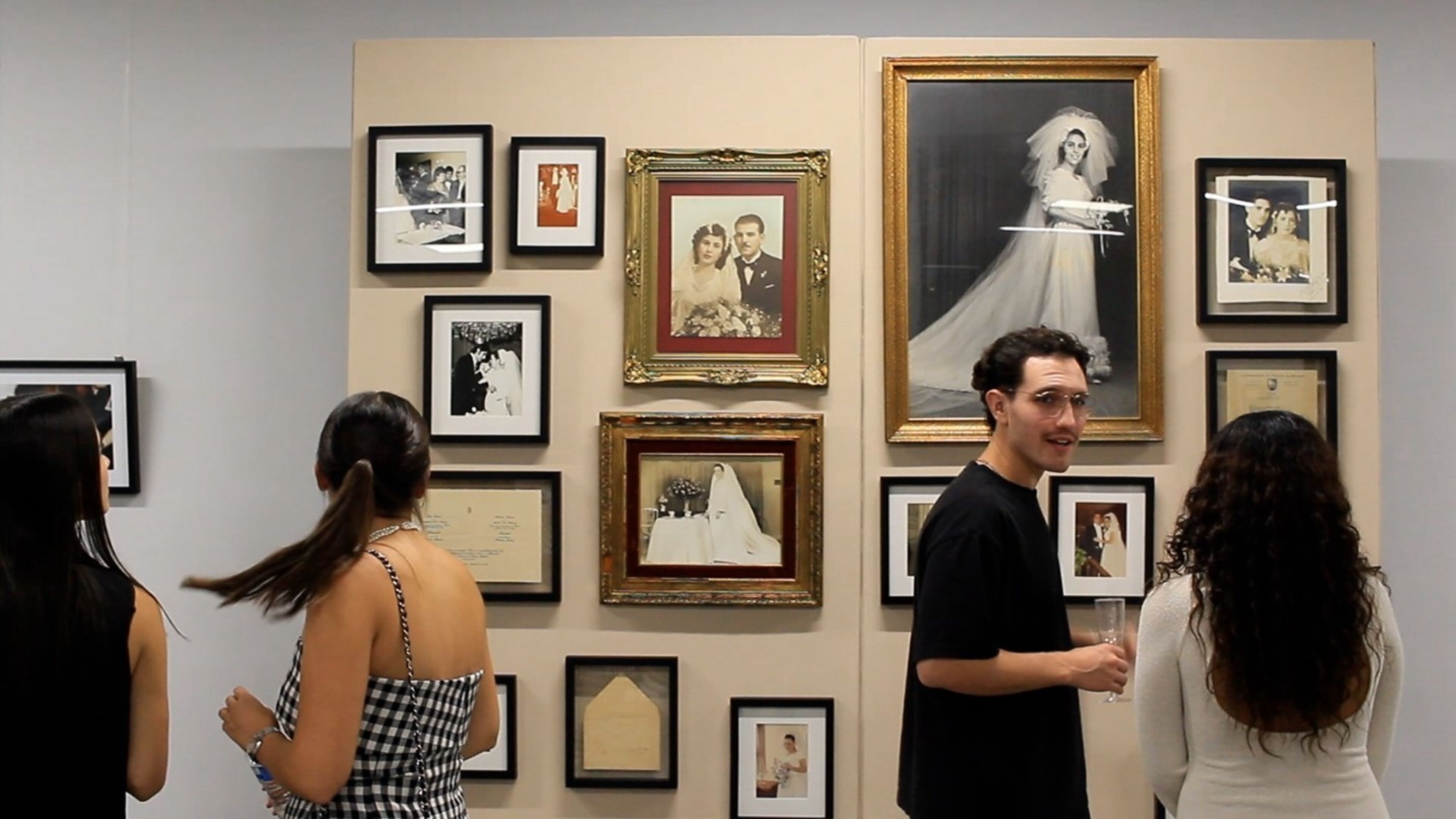 Visitantes observando una exposición de fotos de boda