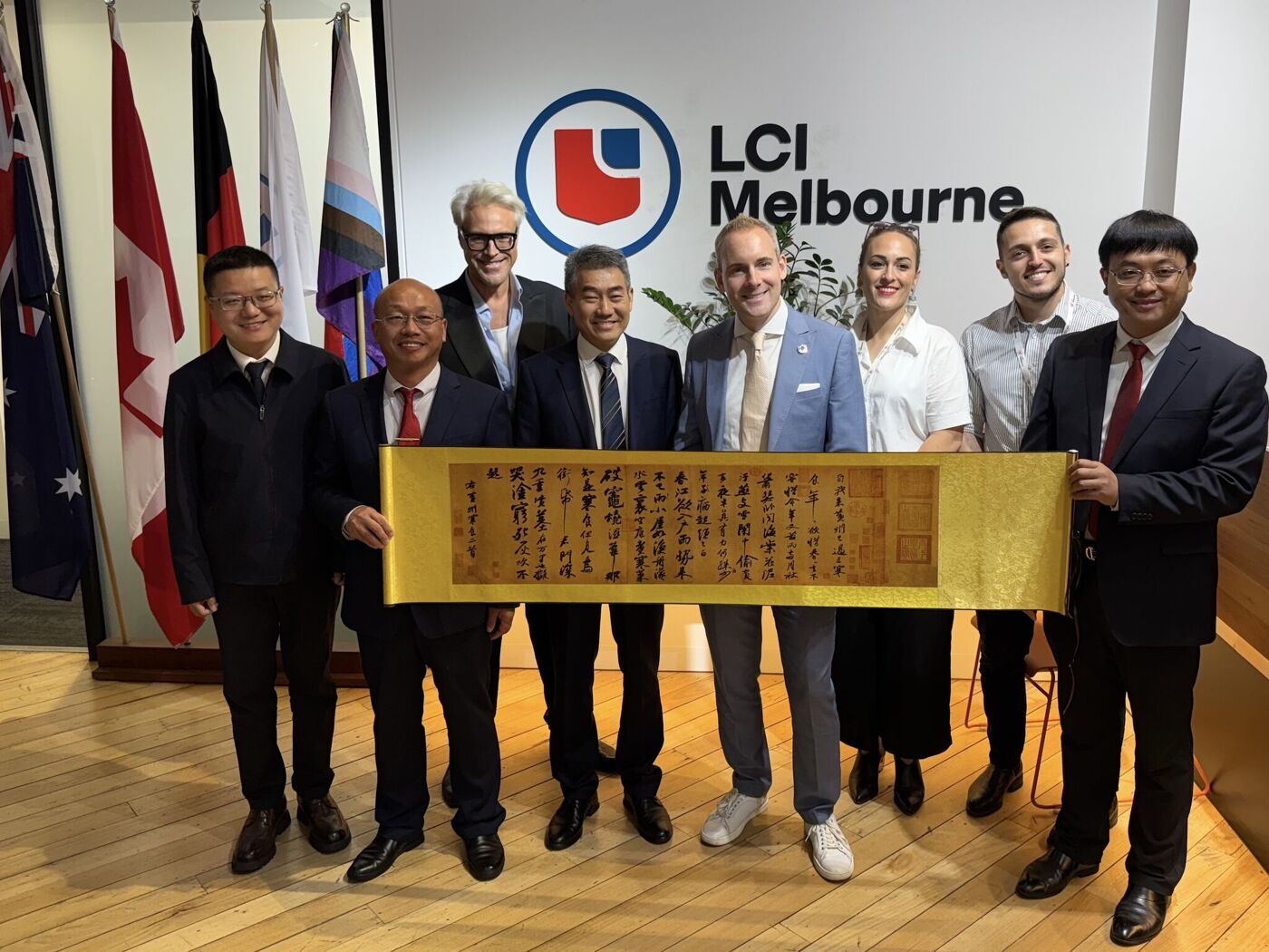 Photo de groupe à LCI Melbourne avec un parchemin commémoratif