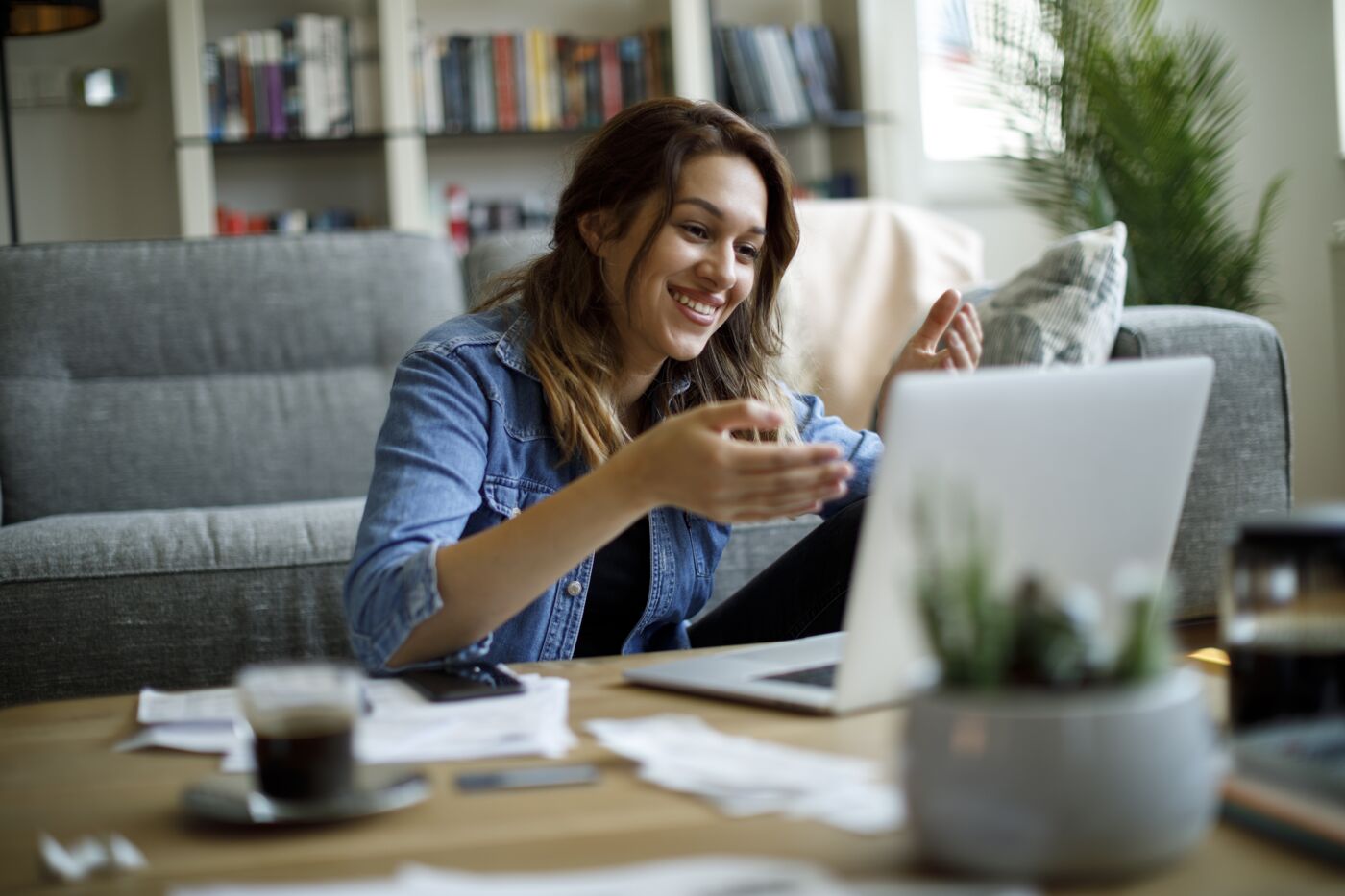 Smiling woman attends an online course at home in her living room.
