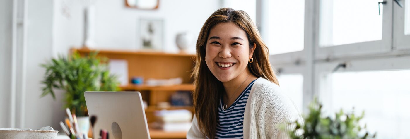 Young woman sitting at desk working on laptop