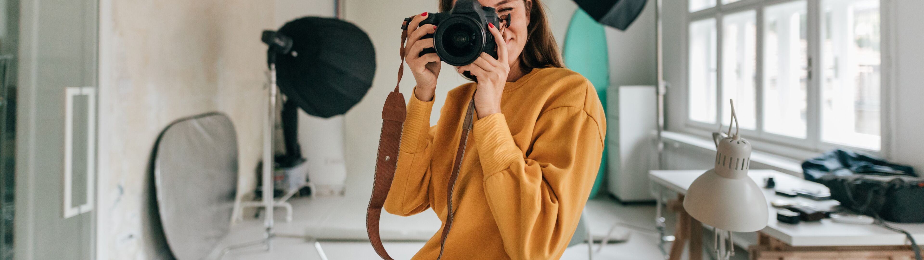 Un fotógrafo en un estudio mirando a través de una cámara 