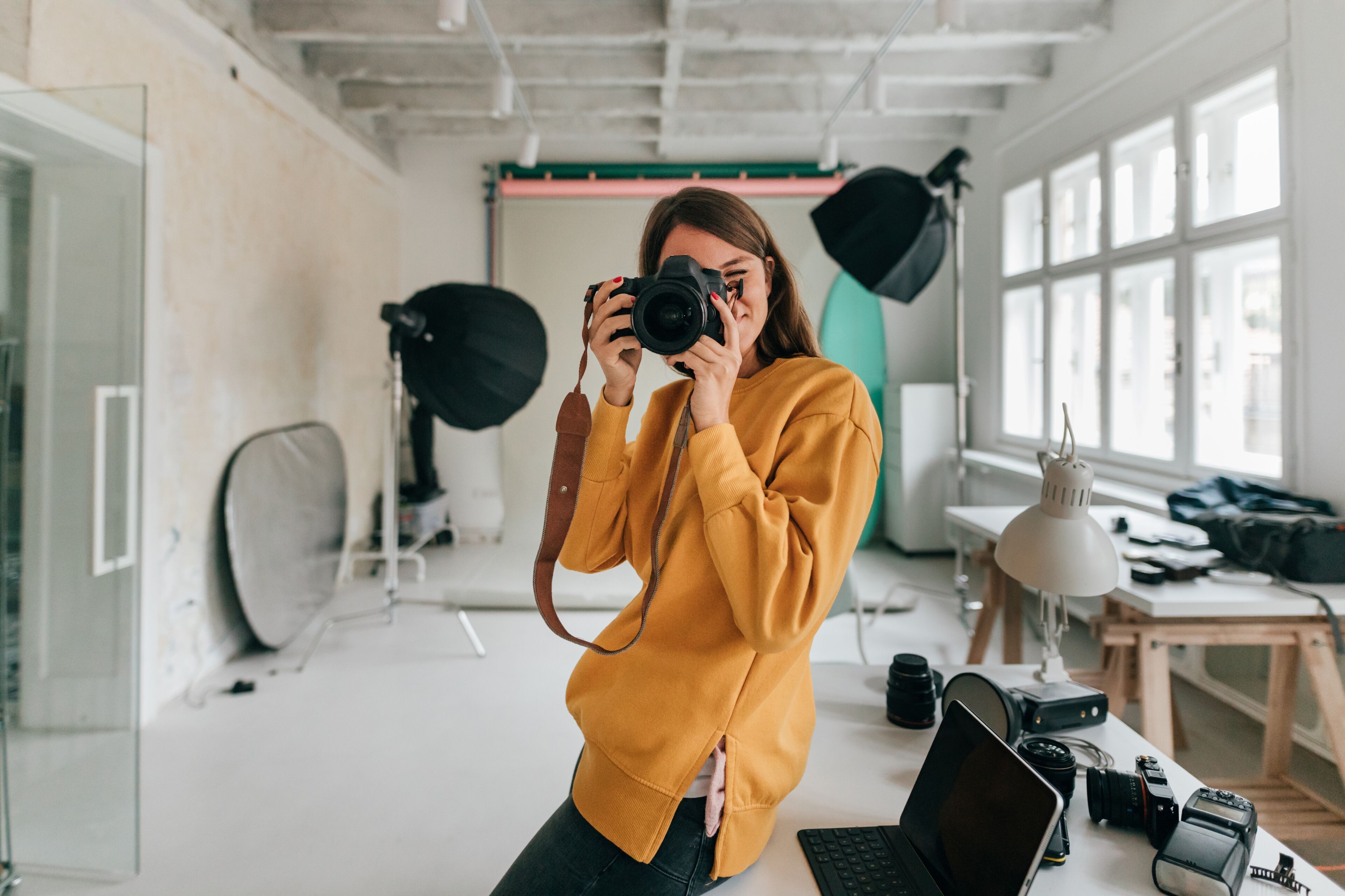 Un photographe dans un studio regardant à travers un appareil photo 