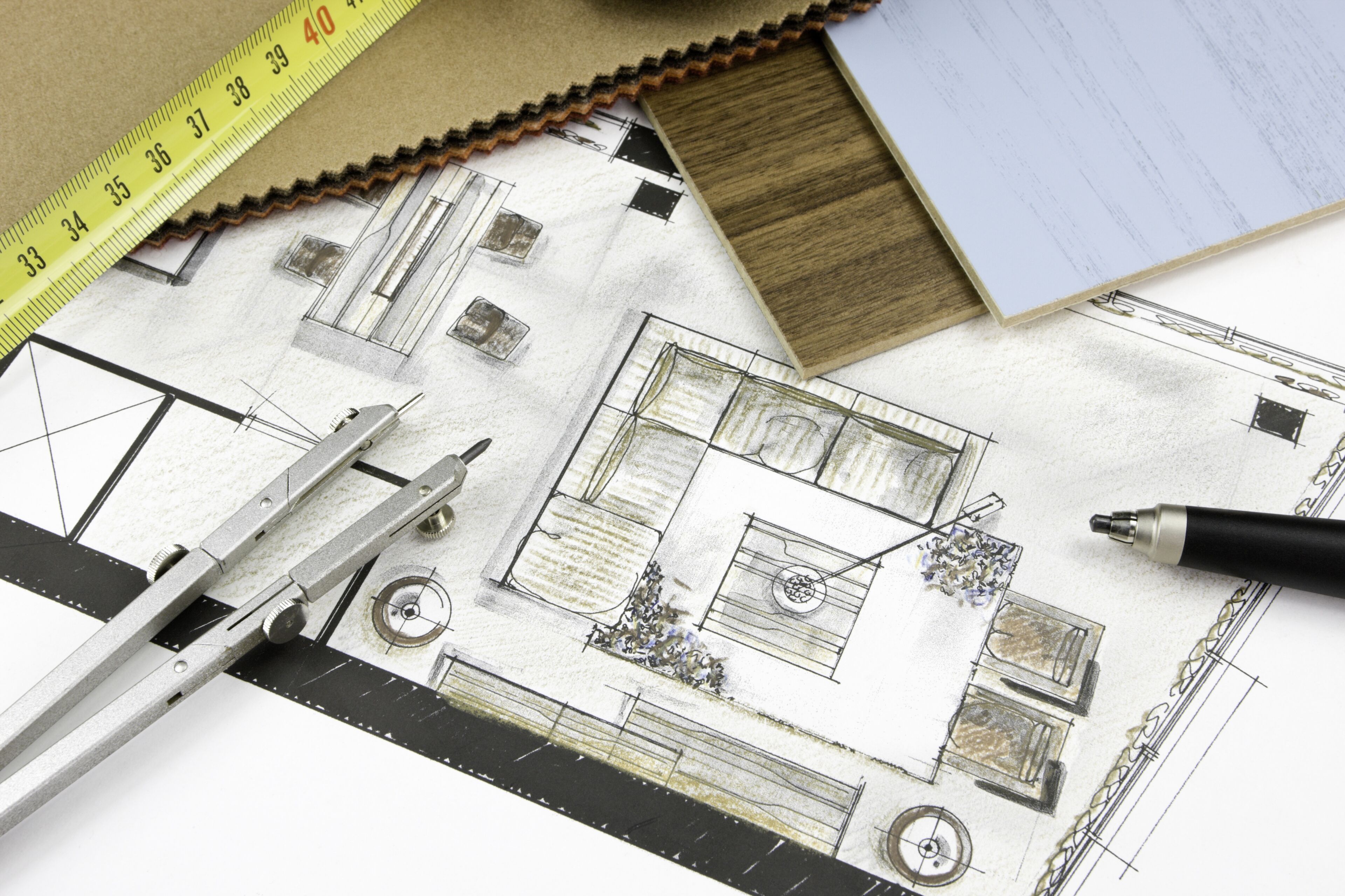 Un plan d'architecture détaillé avec règle, compas et échantillons de matériaux, indiquant un design en cours.