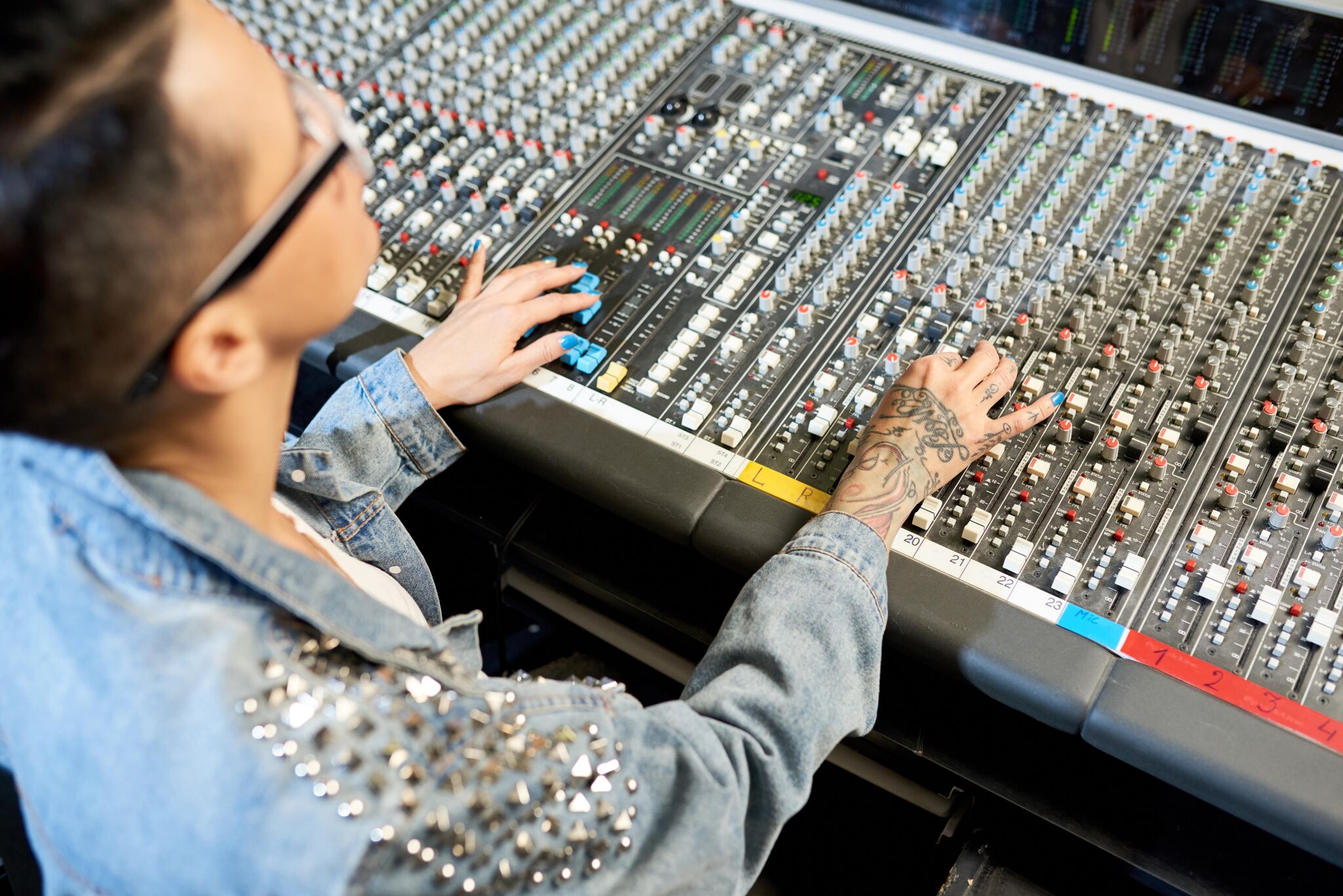 Ingeniero de sonido ajustando la consola de audio en estudio