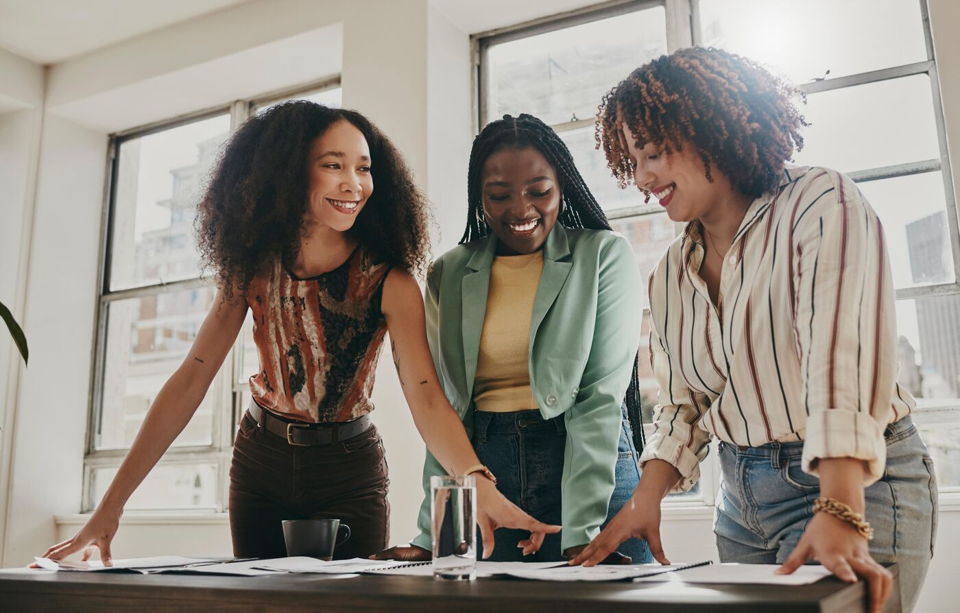 Teamwork, collaboration and planning black women with documents, paperwork or design strategy in office. Business startup, gender equality and marketing ideas of diversity people in workspace meeting  