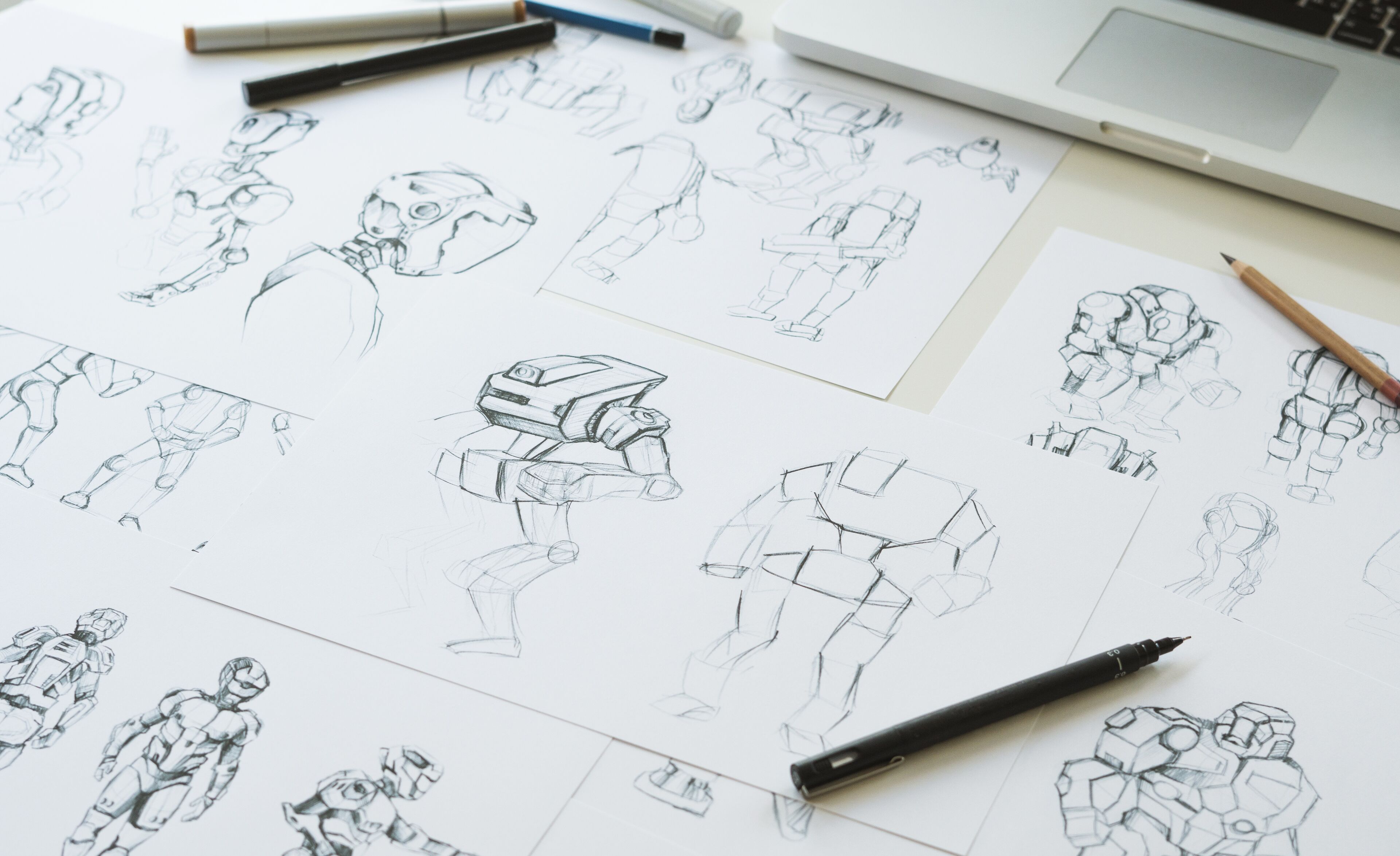 Múltiples bocetos de un personaje robot en varias poses esparcidos por el espacio de trabajo de un diseñador, ilustrando el proceso de desarrollo de conceptos.