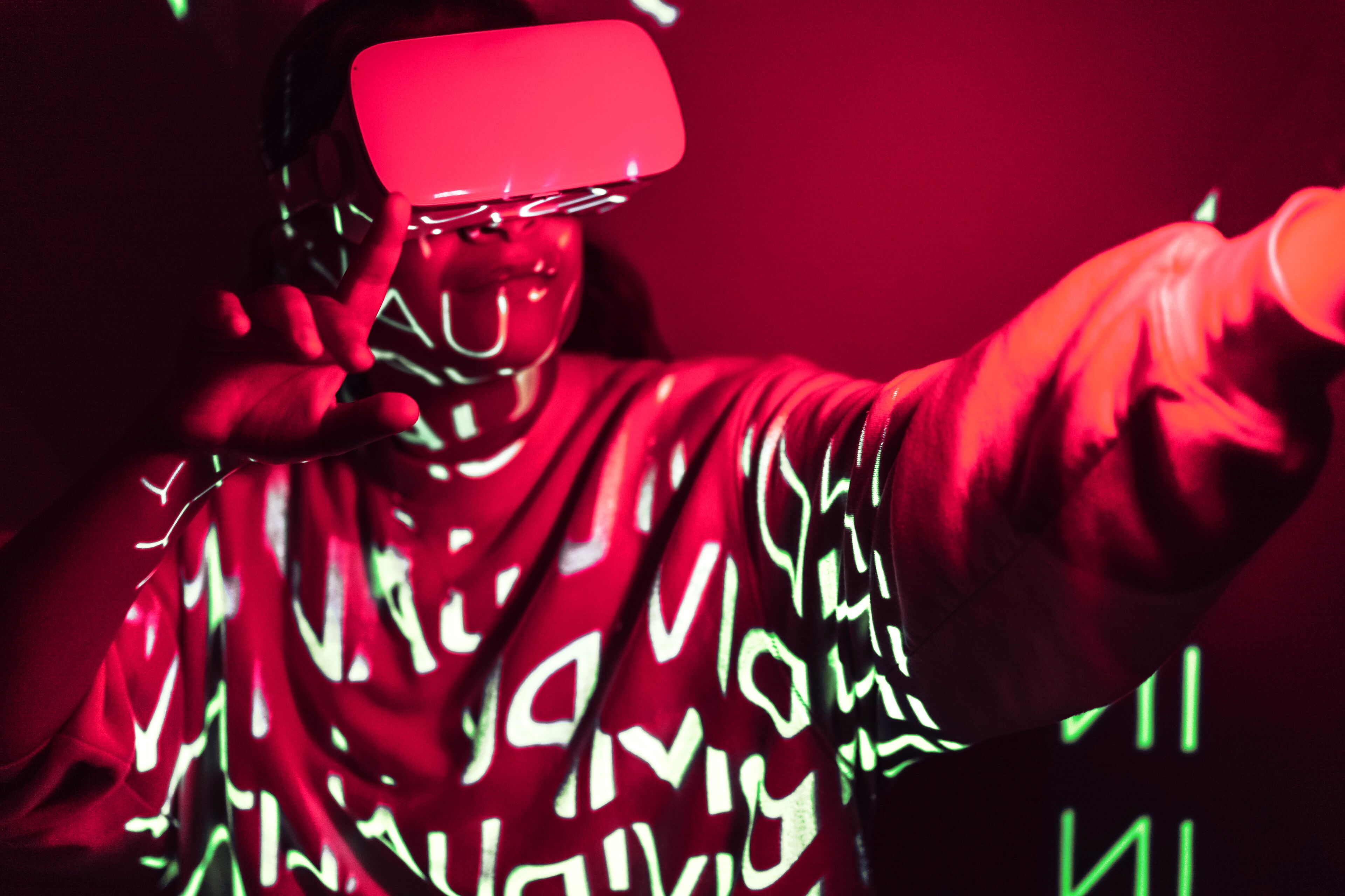 Un individu immers en una simulació de realitat virtual, amb projeccions lluminoses que projecten patrons intricats sobre ell.