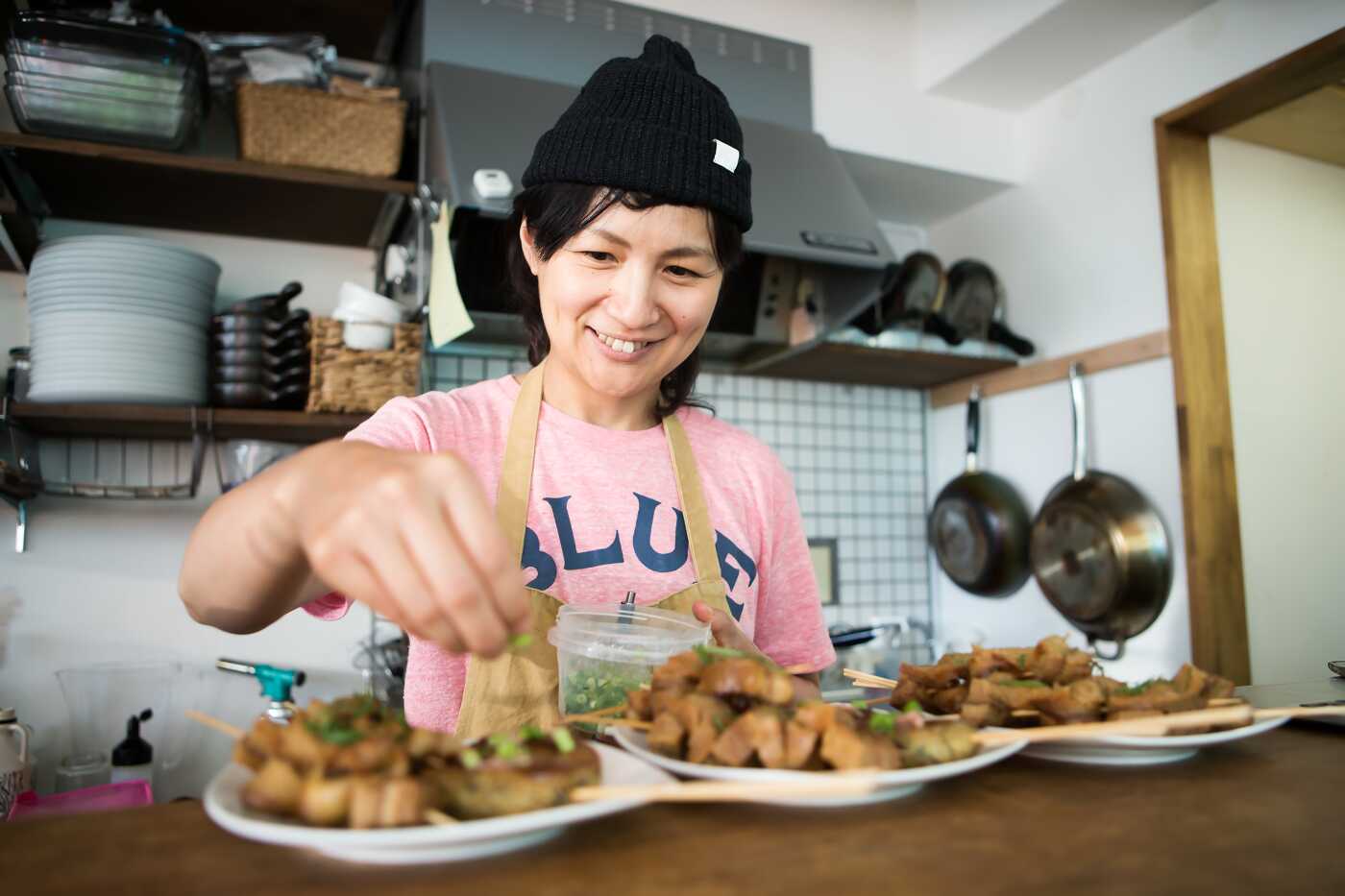 Mujer Aderezando Comida en la Cocina