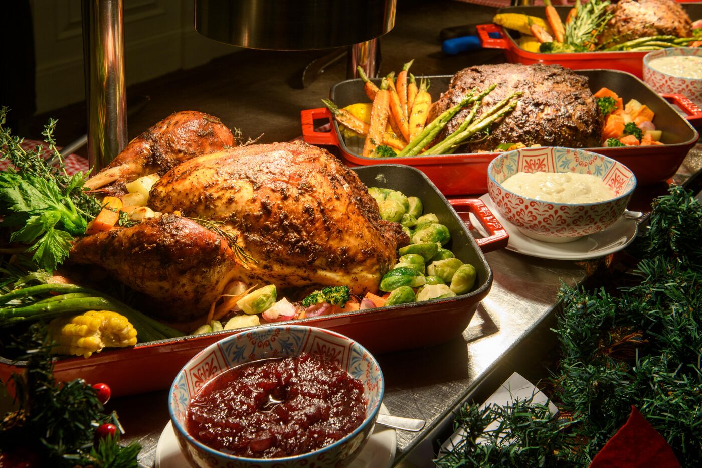 A festive Christmas spread featuring a roasted turkey, vegetables, mashed potatoes, and cranberry sauce, all presented beautifully with holiday decorations.