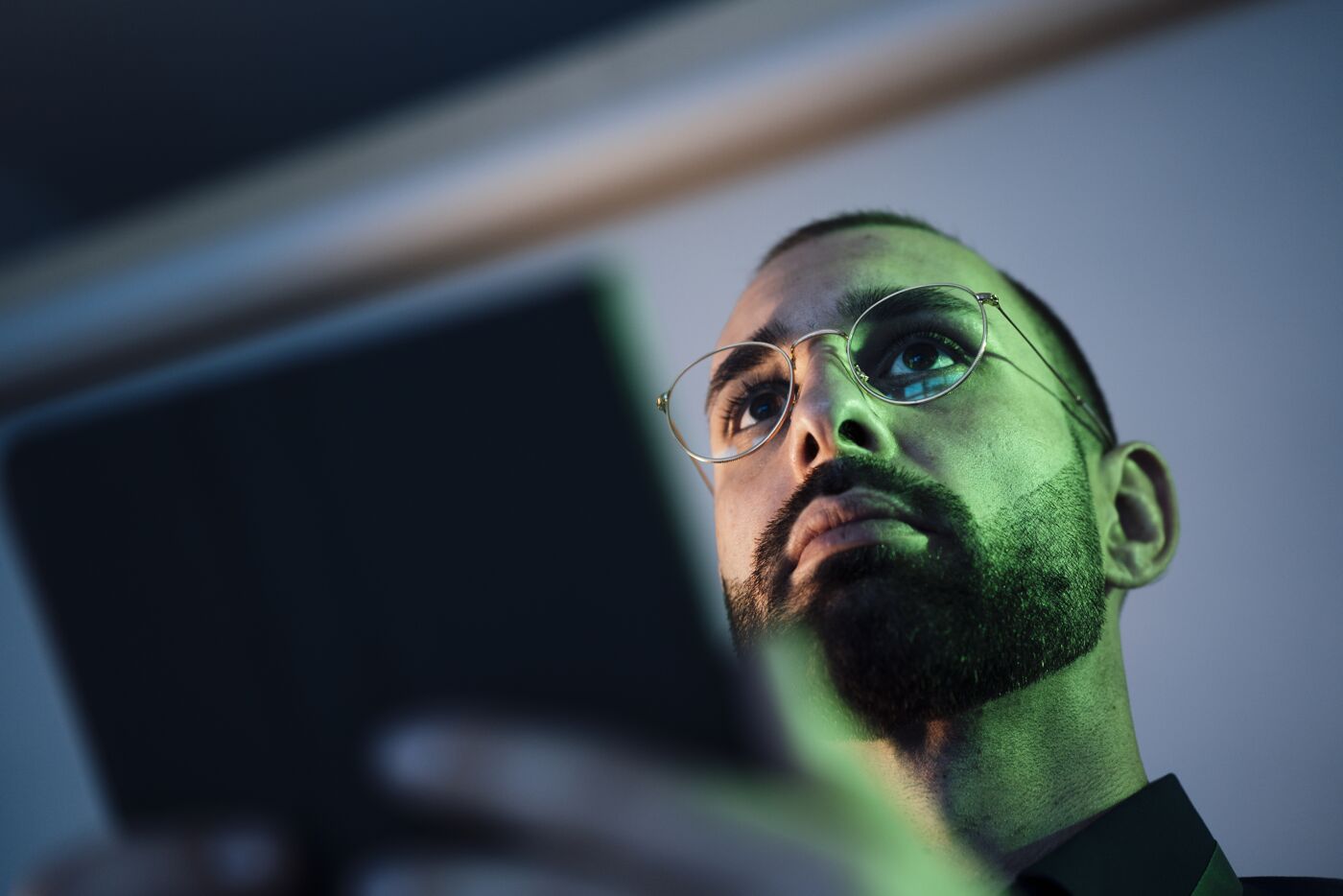 Man Focused on Handheld Device Screen