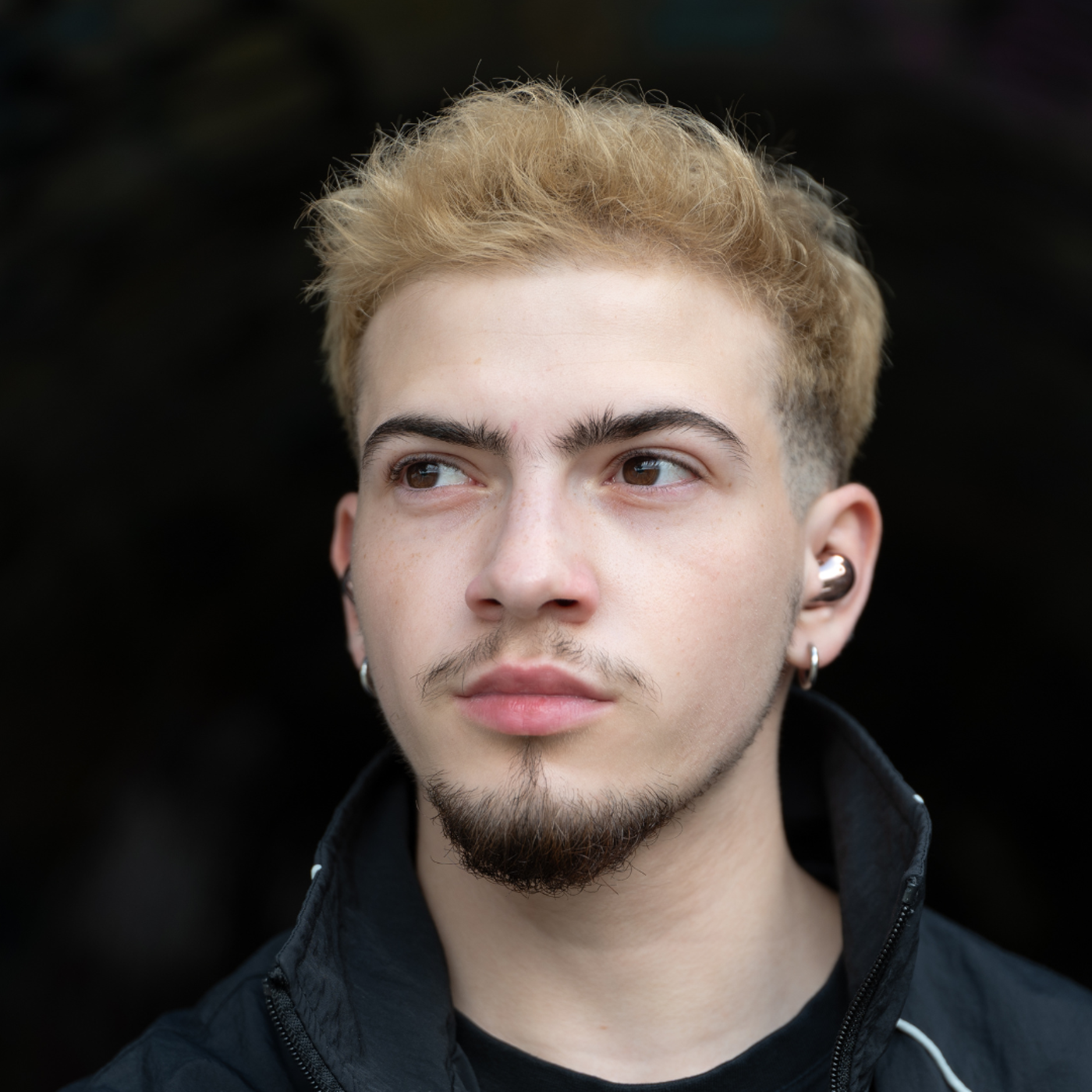 Young Man with Blonde Hair and Ear Piercings