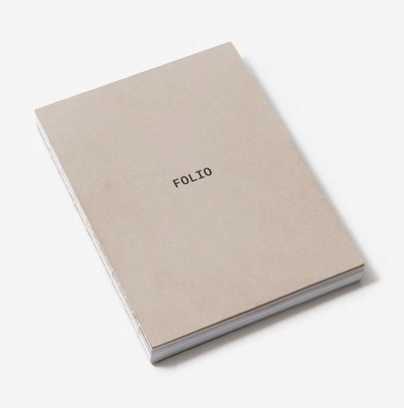 A beige-colored notebook with the word "FOLIO" printed in the center of the cover. The pages are slightly misaligned, giving it a worn appearance.