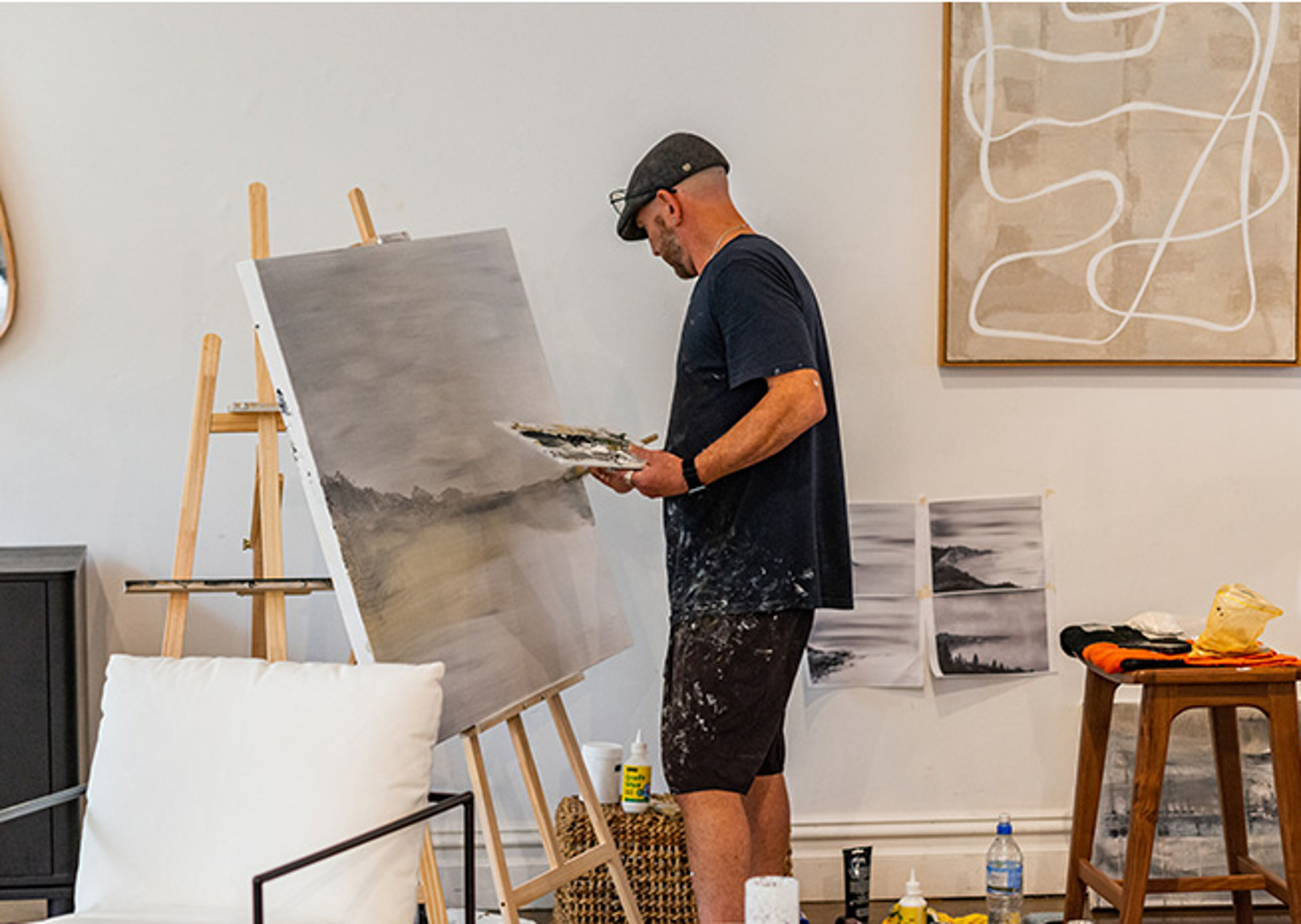 An artist immersed in his craft, the studio a canvas itself for the creative process unfolding.
