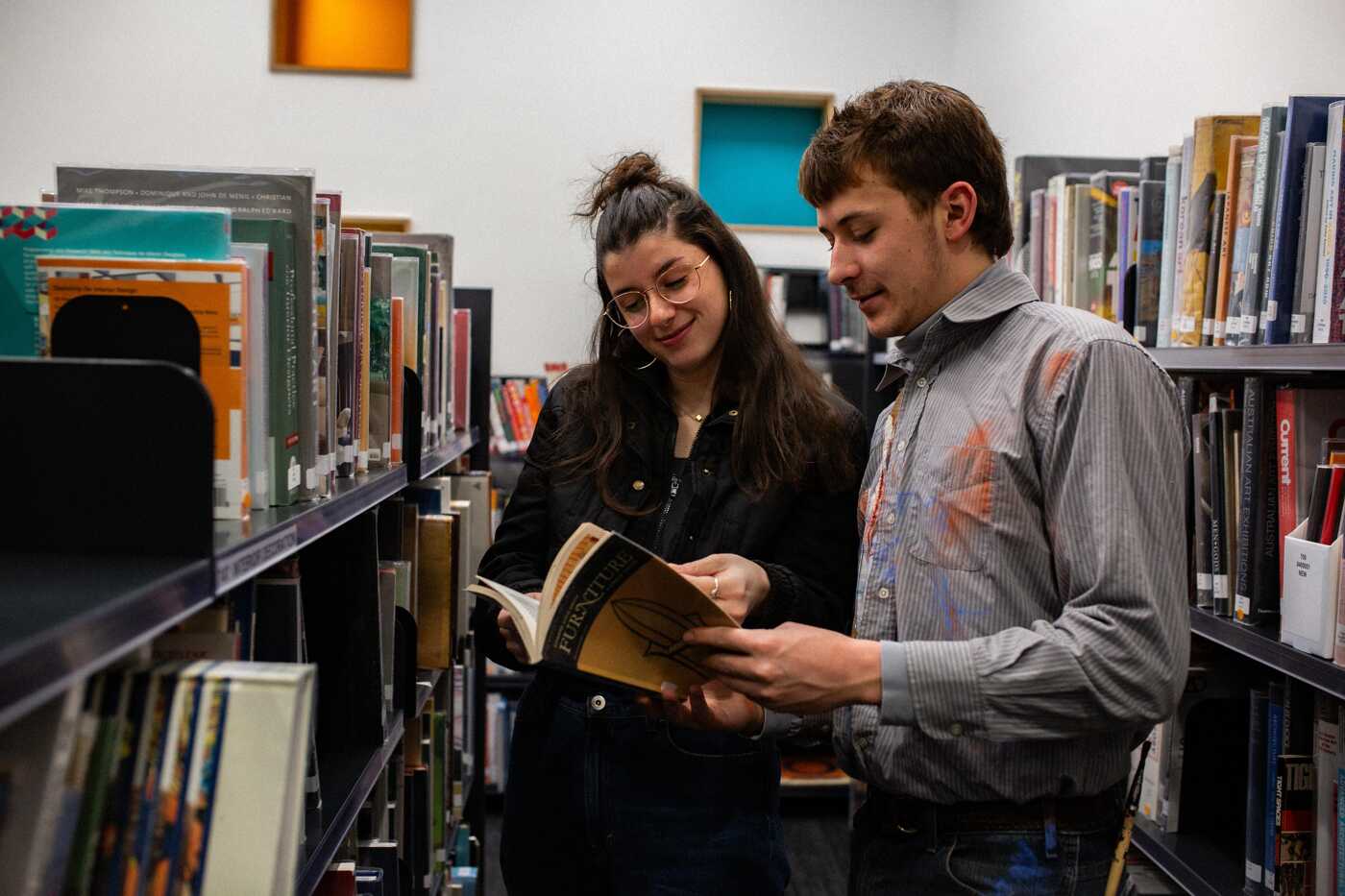 Students Exploring Books in a Library