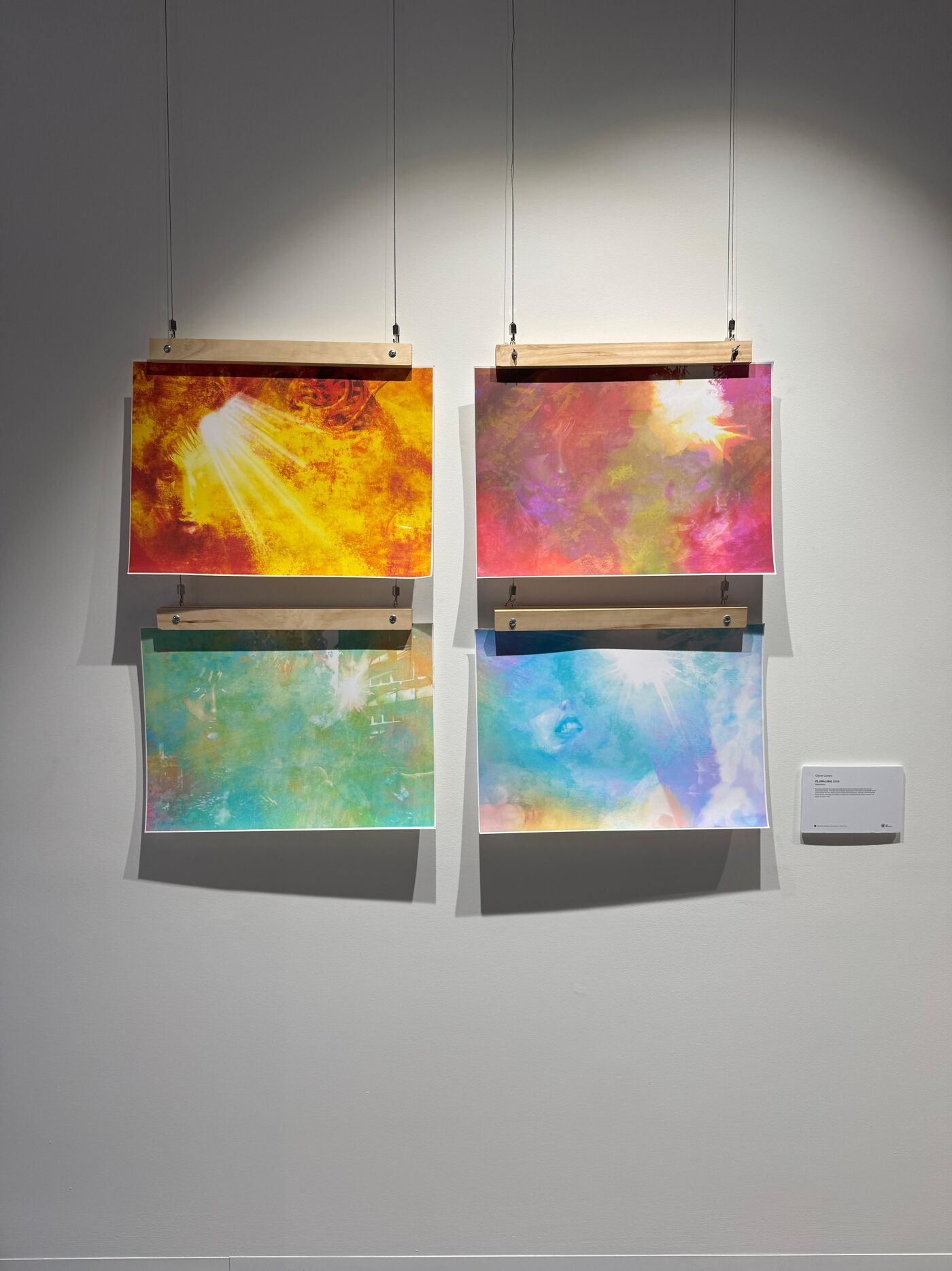 This is an image of four abstract artworks hanging on a wall, each featuring vibrant colors and soft textures.