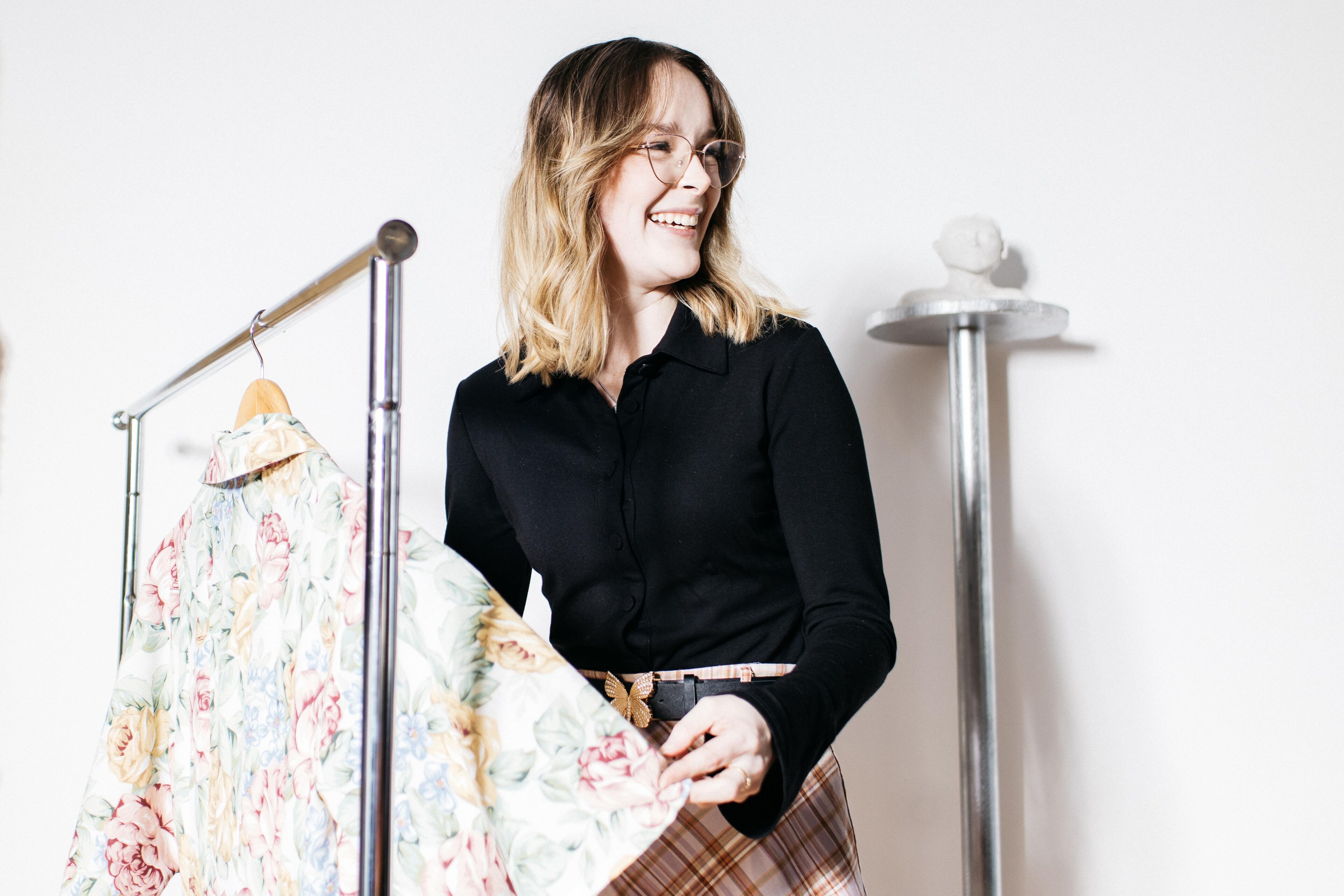 Woman Smiling While Holding a Floral Coat