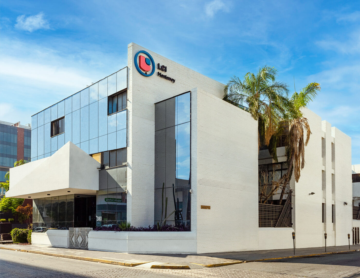 Modern corporate building with a striking white facade under a clear blue sky.