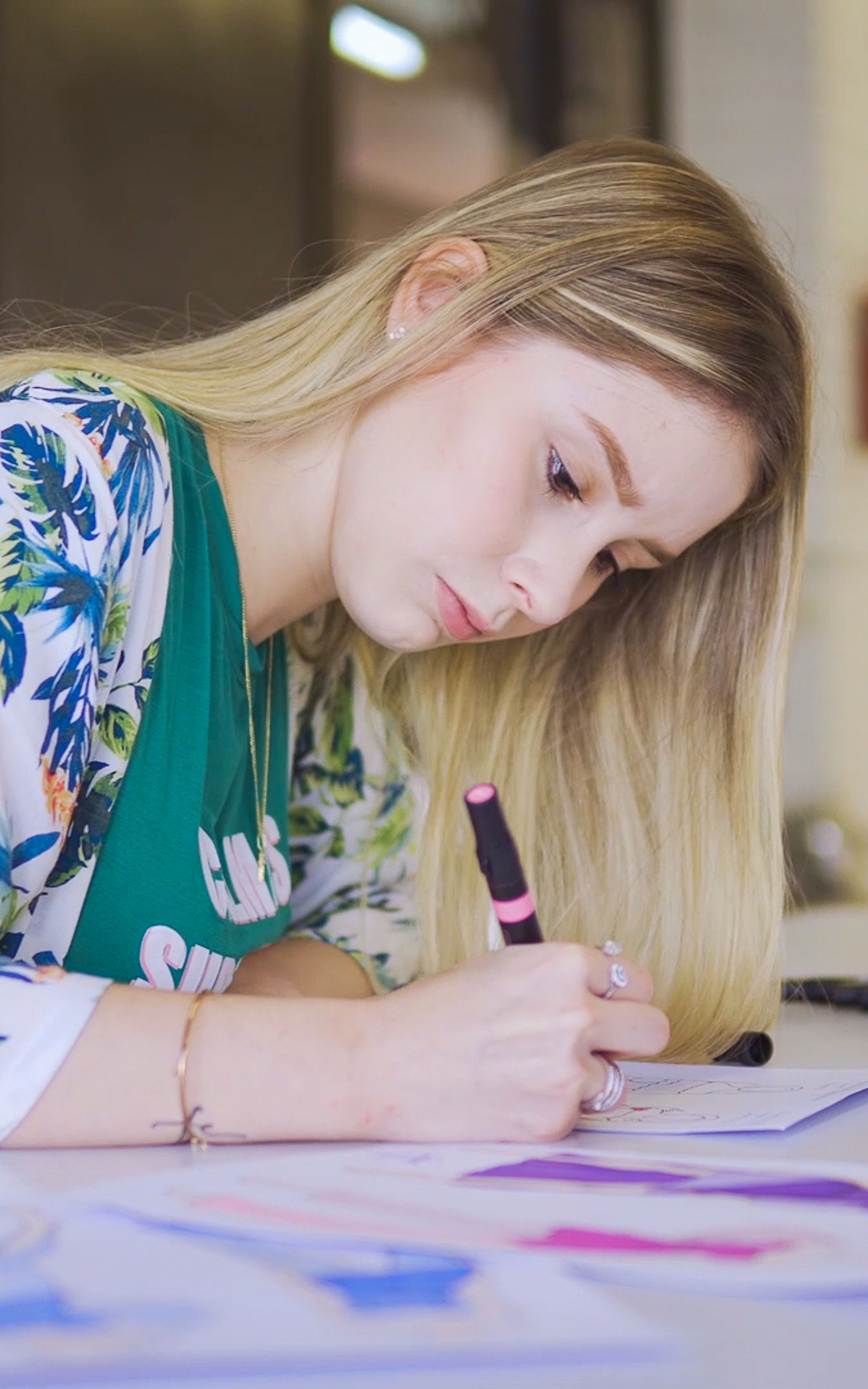 A diligent student immerses herself in sketching designs, a portrait of concentration.