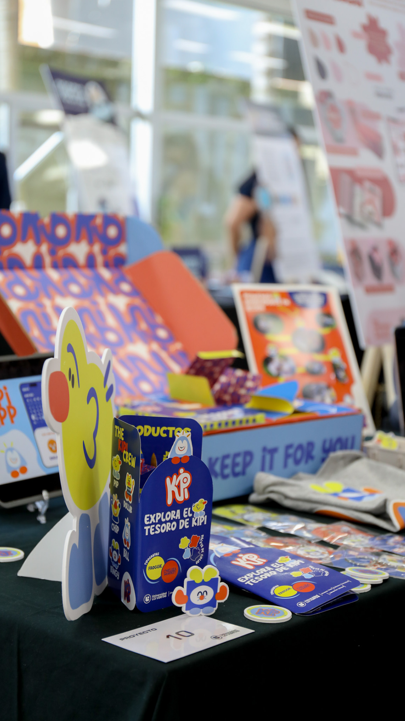 The image showcases a vibrant display of promotional materials, including a cartoon character, boxes, and brochures, likely for a product or event.