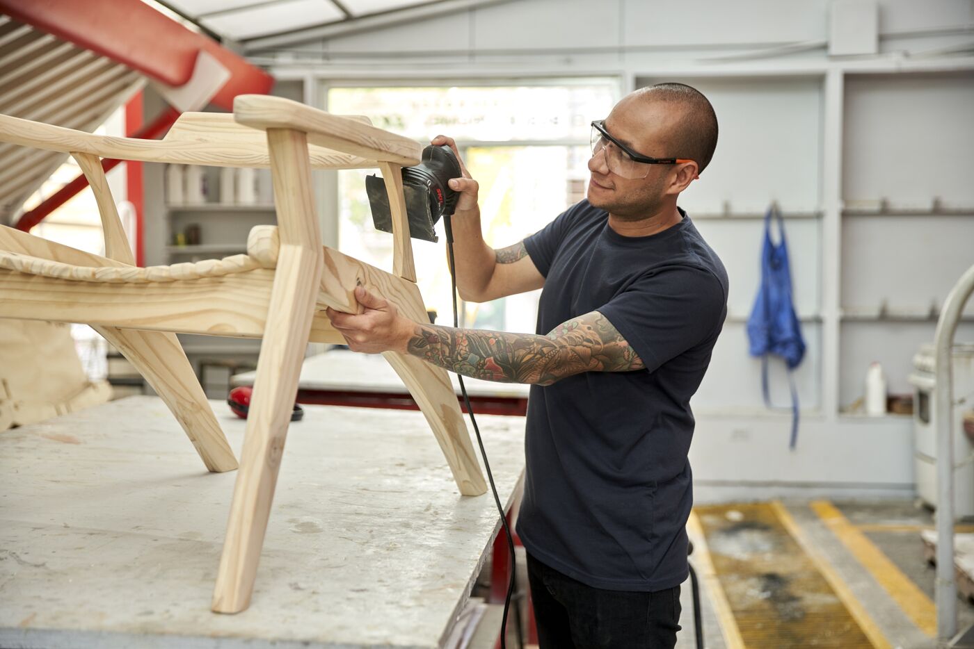 Craftsman Sanding a Wooden Chair