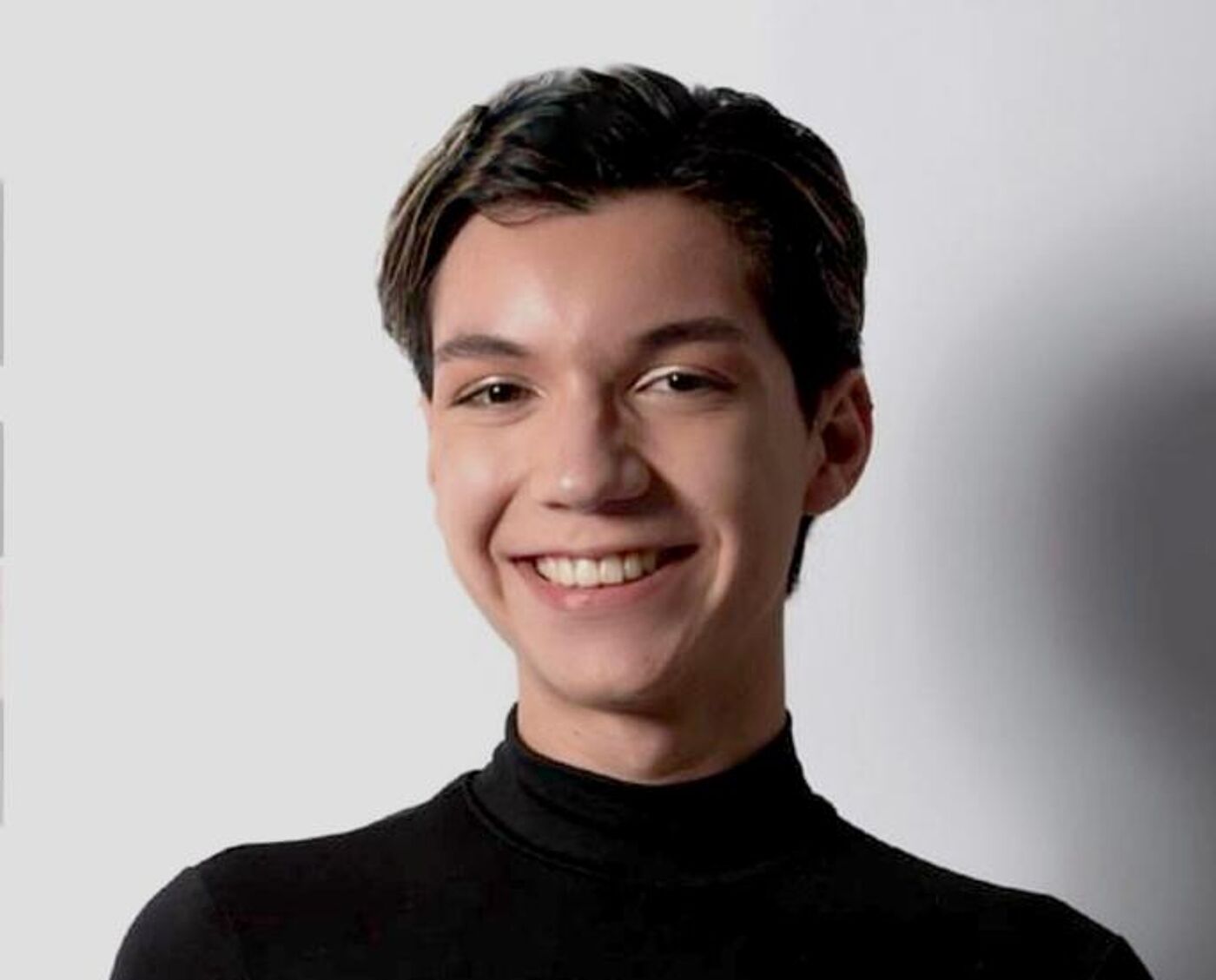 Joven Sonriente en Jersey de Cuello Alto Negro