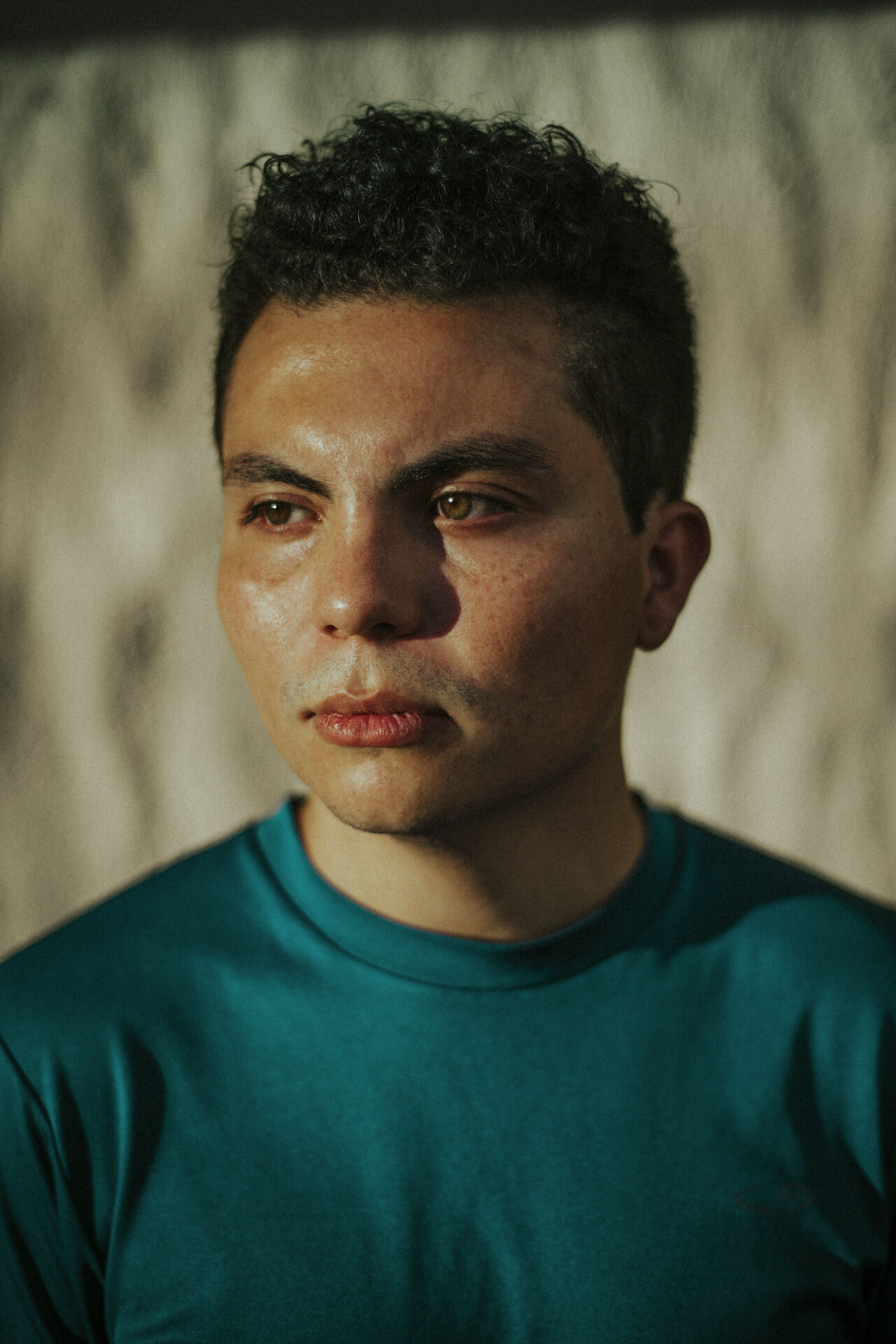 Hombre pensativo con camisa color verde azulado