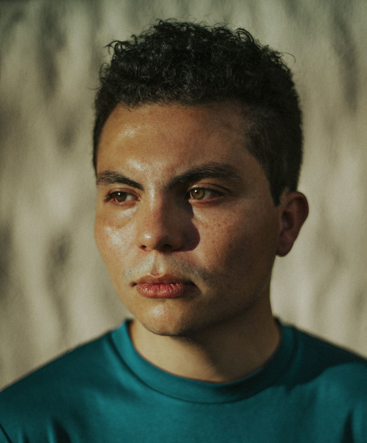 Hombre pensativo con camisa color verde azulado