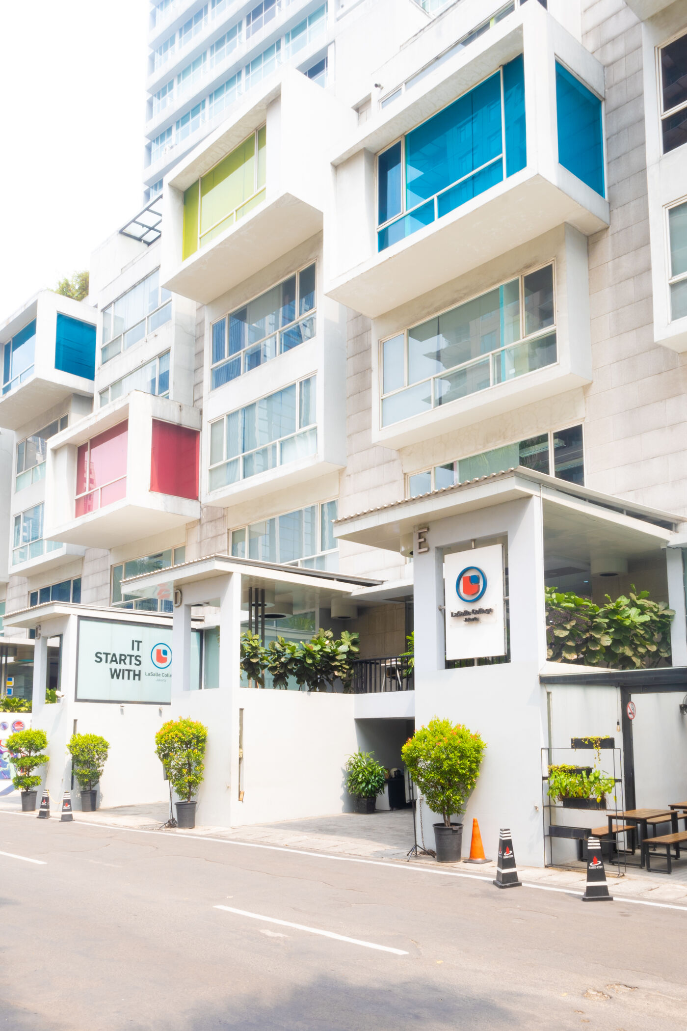 A contemporary office building with colorful balcony accents under a clear sky.