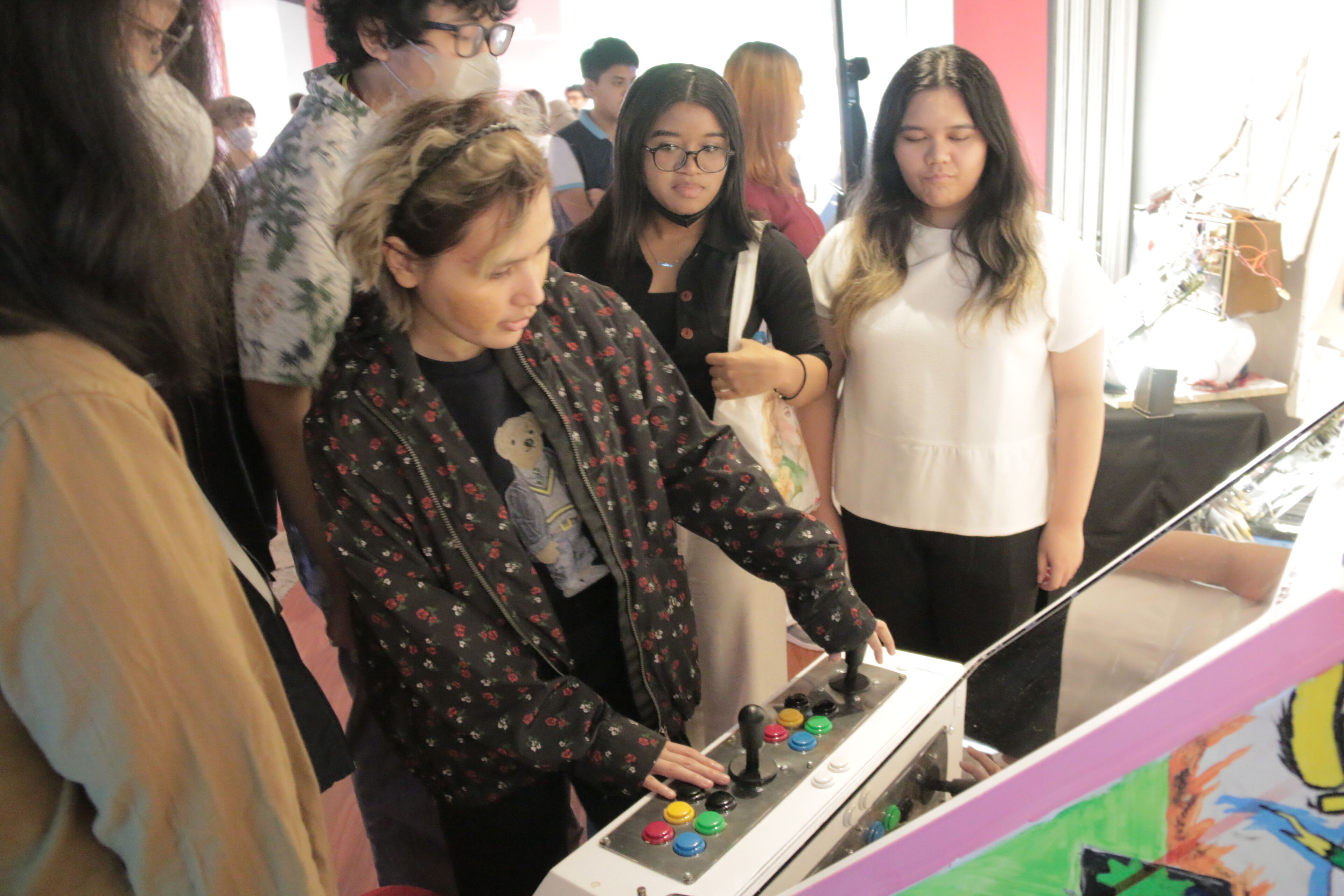A group of individuals engaging with an arcade game, intensely focused on the activity.