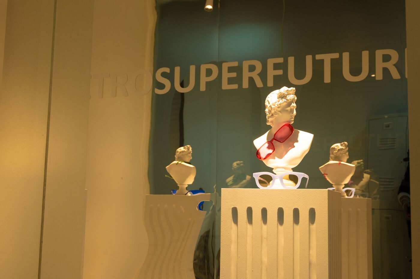 Exhibición Moderna de Gafas con Bustos Clásicos