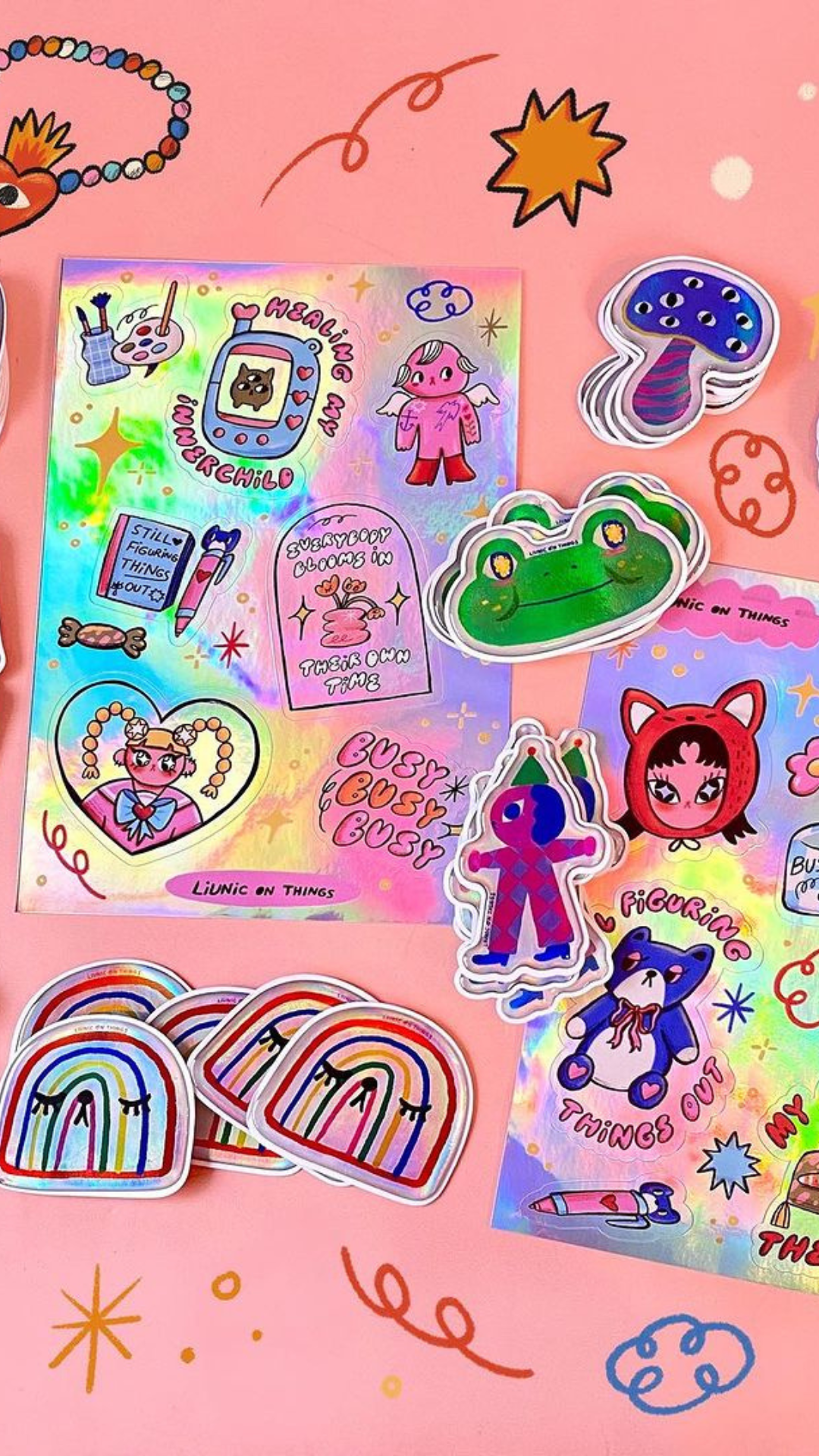  A vibrant assortment of playful stickers featuring rainbows, characters, and positive messages on a pink background.
