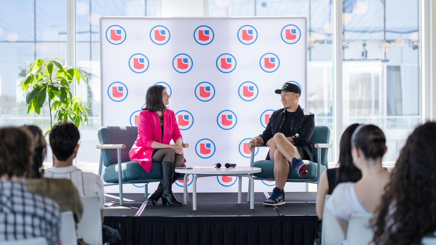 Two people are seated on chairs facing an audience, with a backdrop featuring the Leclerc logo.