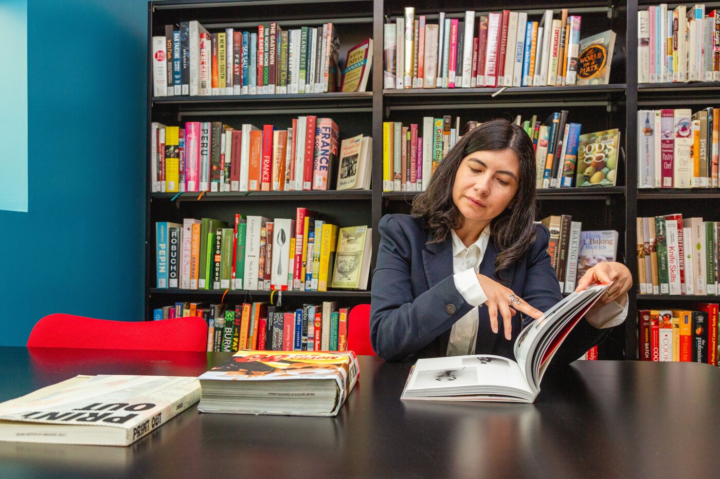 In a serene environment, a woman engrosses herself in a book, surrounded by books and colour, symbolic of the never-ending journey of learning.