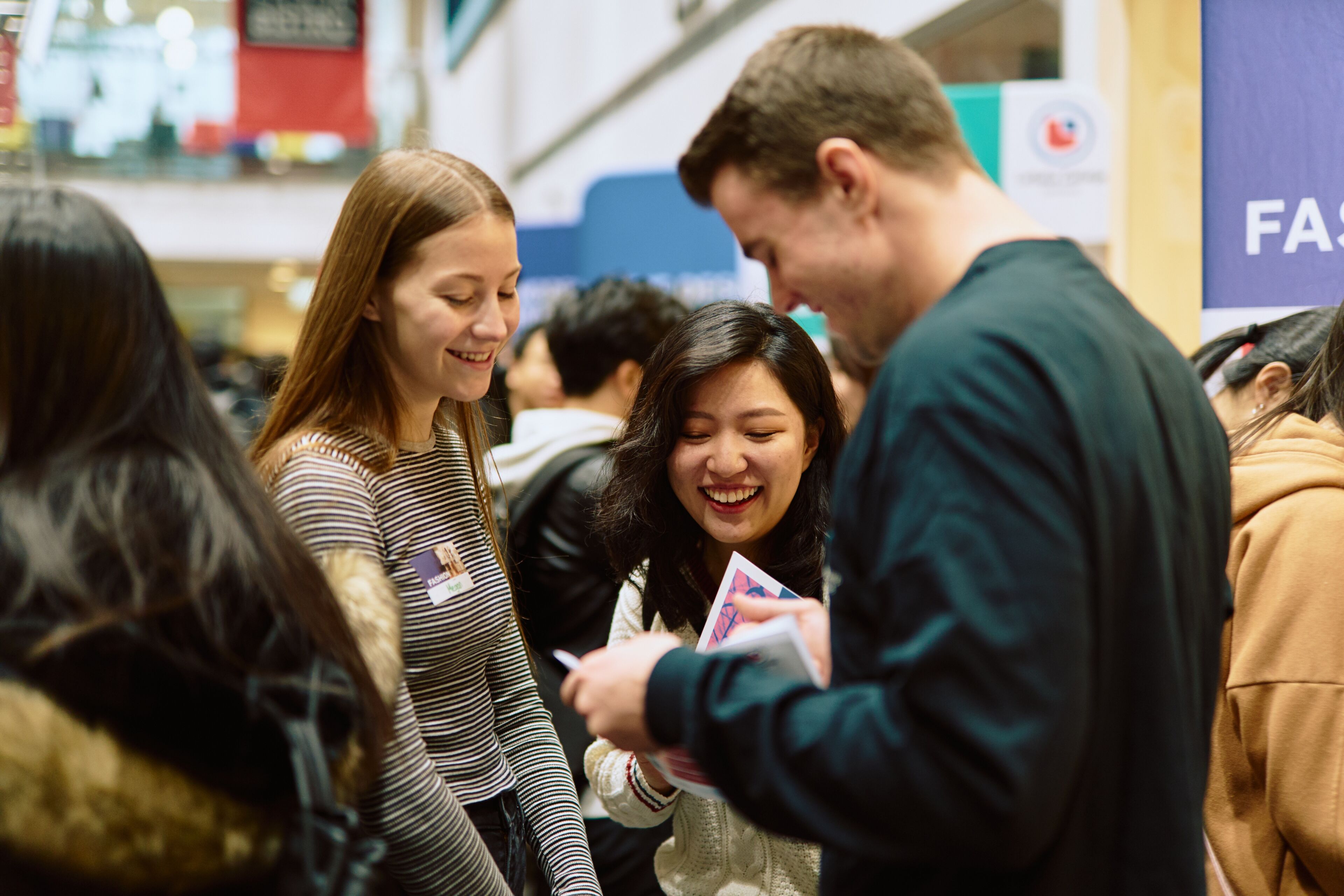 Joyful students exchange ideas and share a laugh at a college networking event.