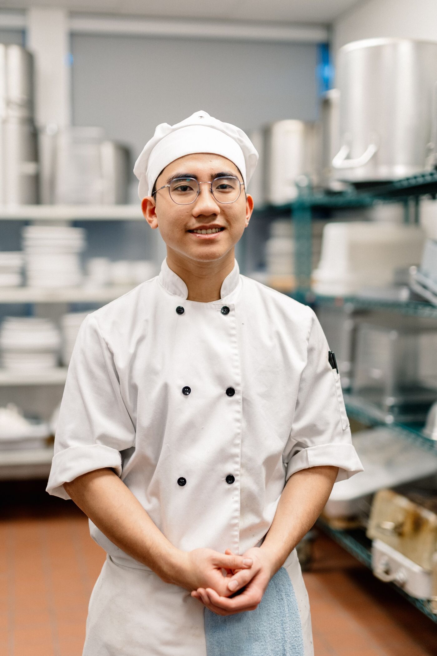 A confident culinary student stands ready in the kitchen, exemplifying the blend of discipline and passion vital for the gastronomic arts.