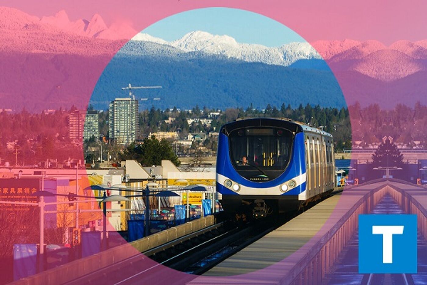 A modern train moves along an elevated track in an urban landscape, with snow-capped mountains in the distance under a clear sky.
