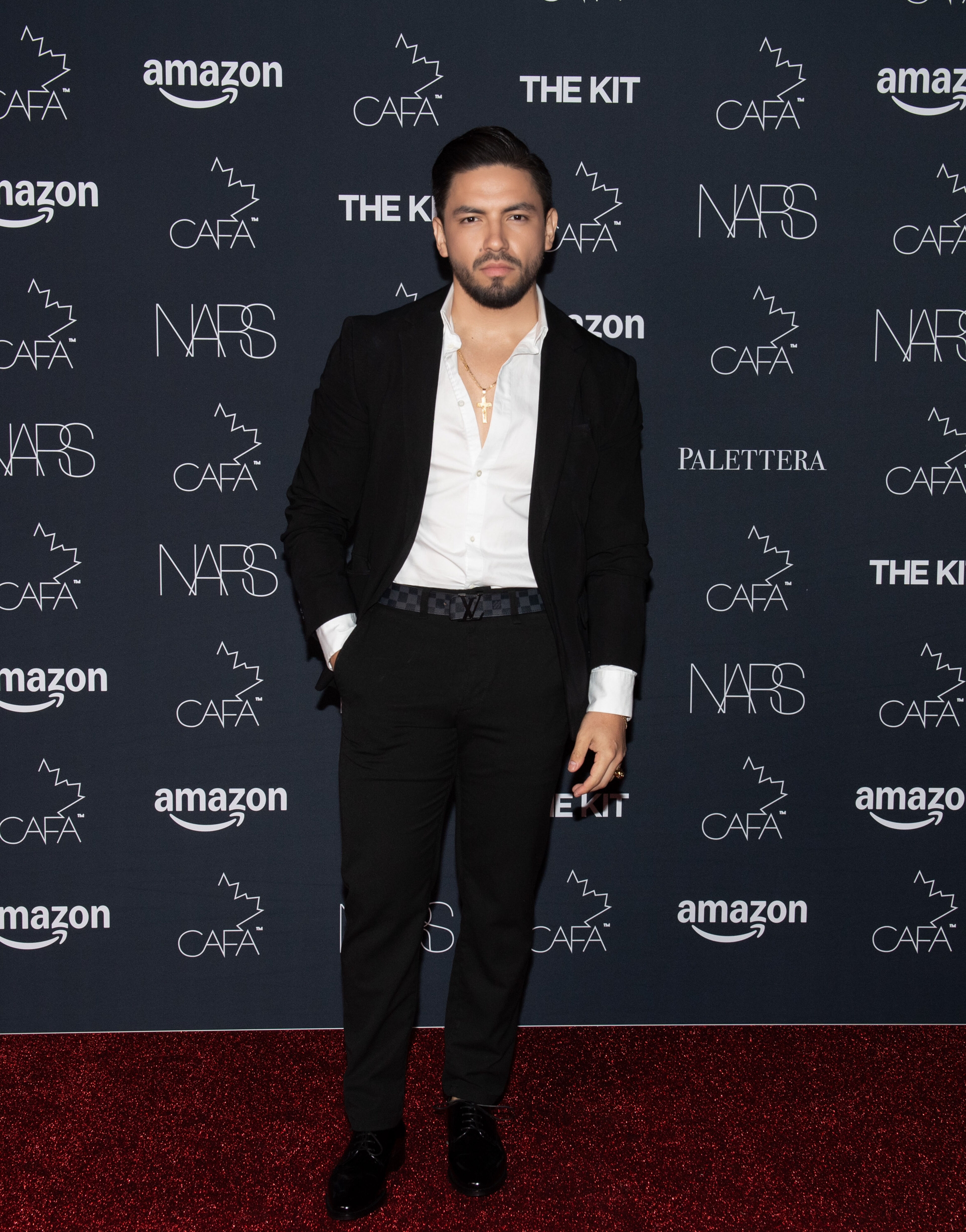  Man in formal attire on the red carpet at a fashion event. 