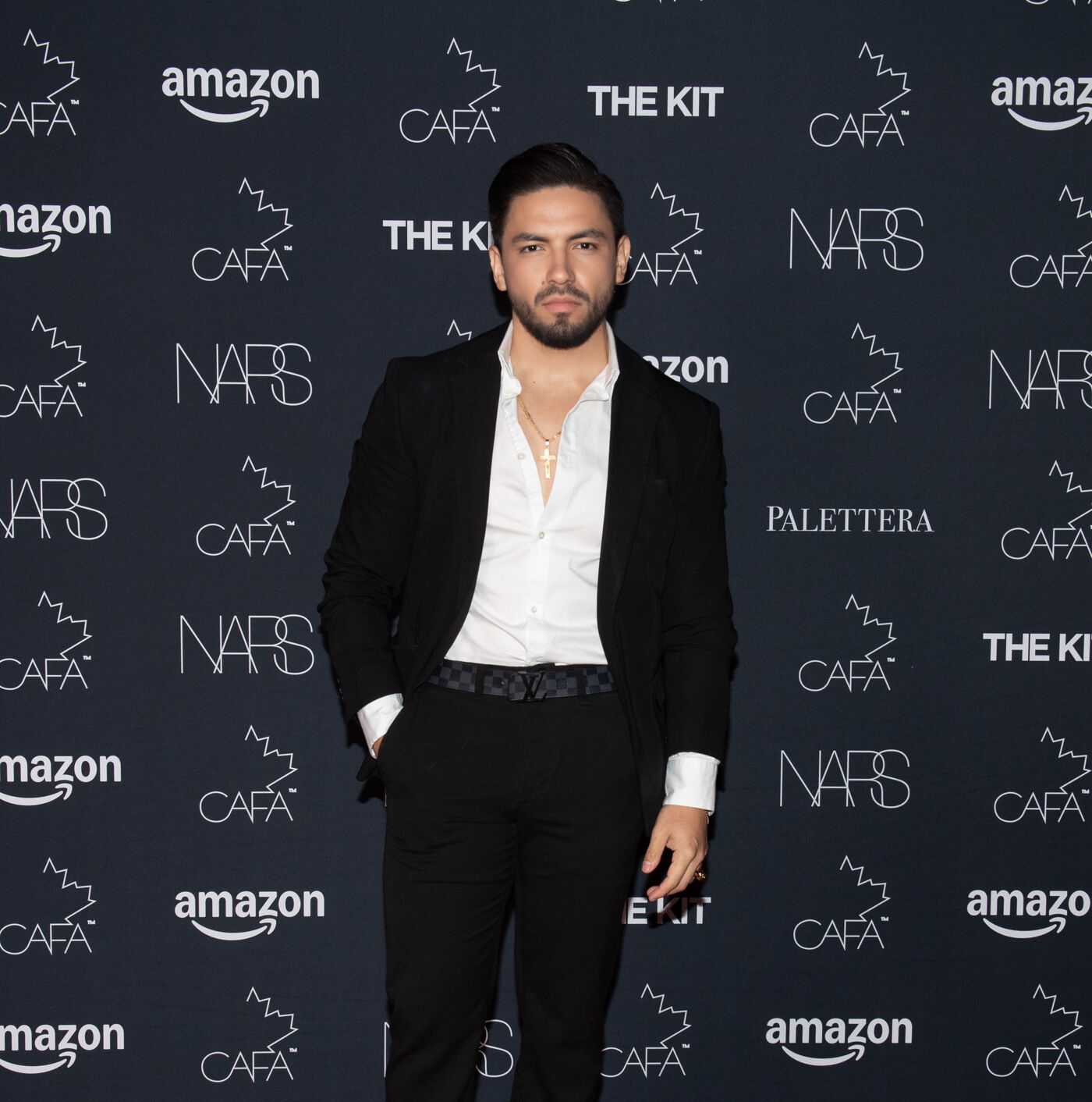 Man in formal attire on the red carpet at a fashion event.