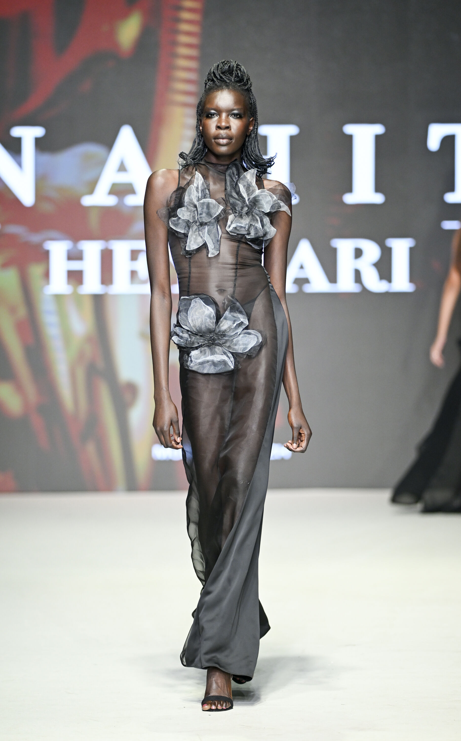 Model Showcasing Sheer Floral Gown on Runway